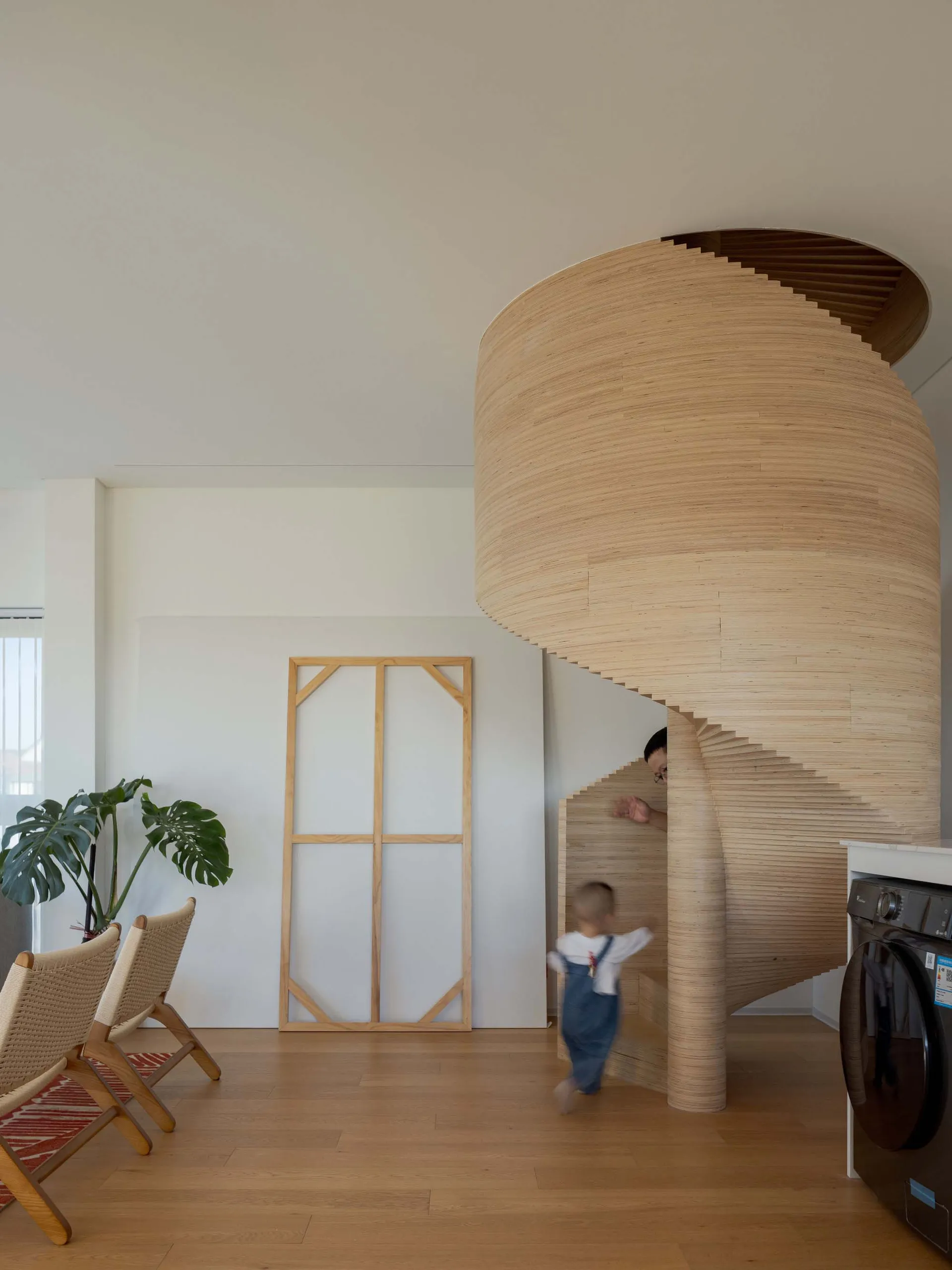 A modern minimalist interior featuring a wooden spiral staircase.