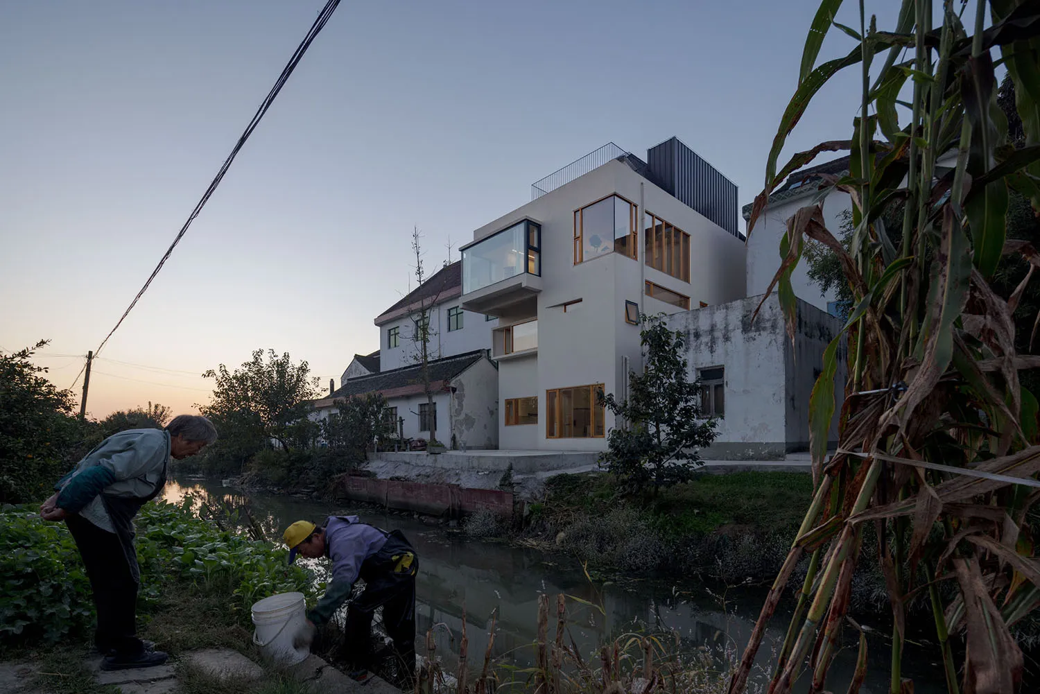 一棟現代住宅坐落於水岸旁,擁有大面玻璃窗與俐落當代設計。
