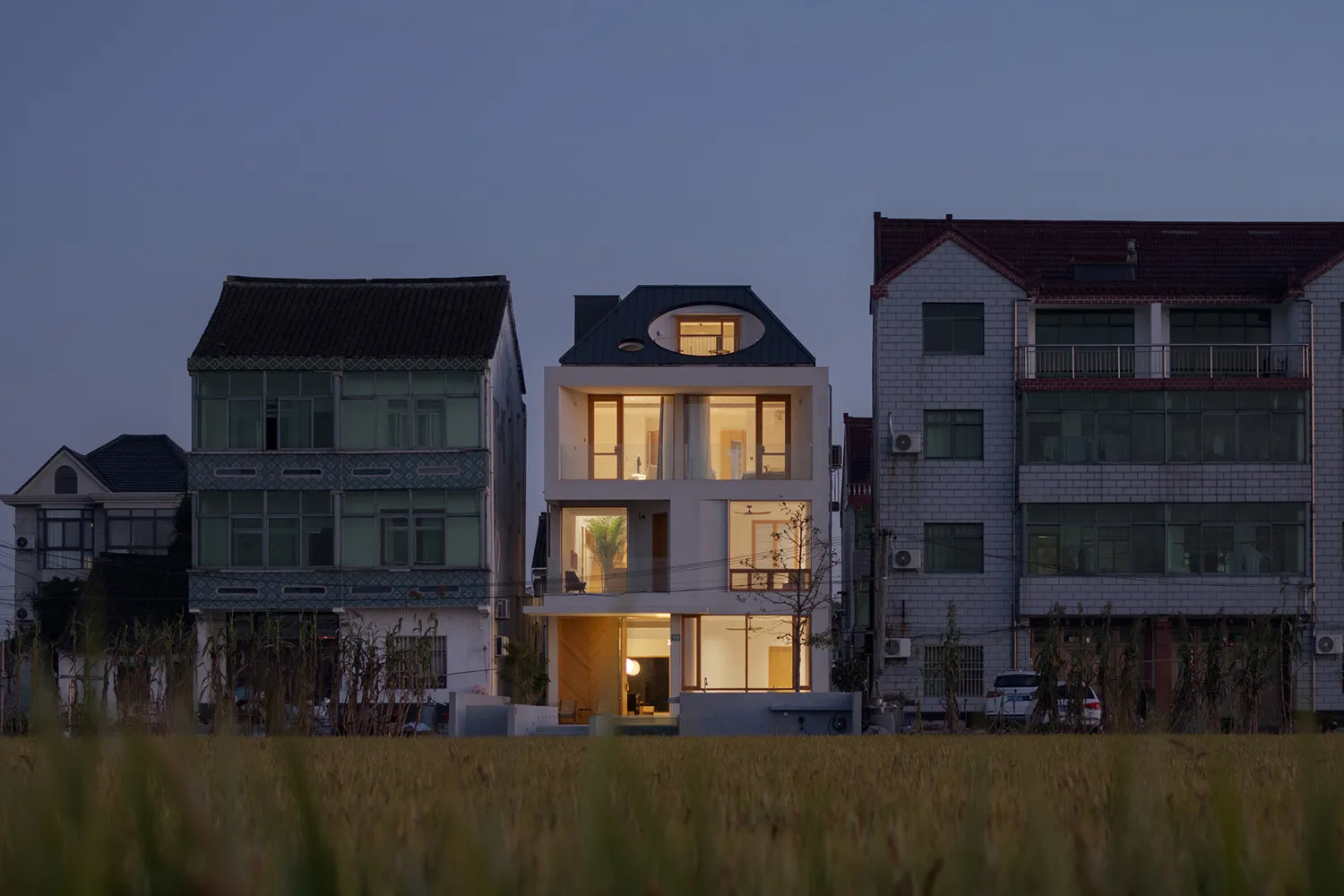 A modern residential house with large glass windows and doors.