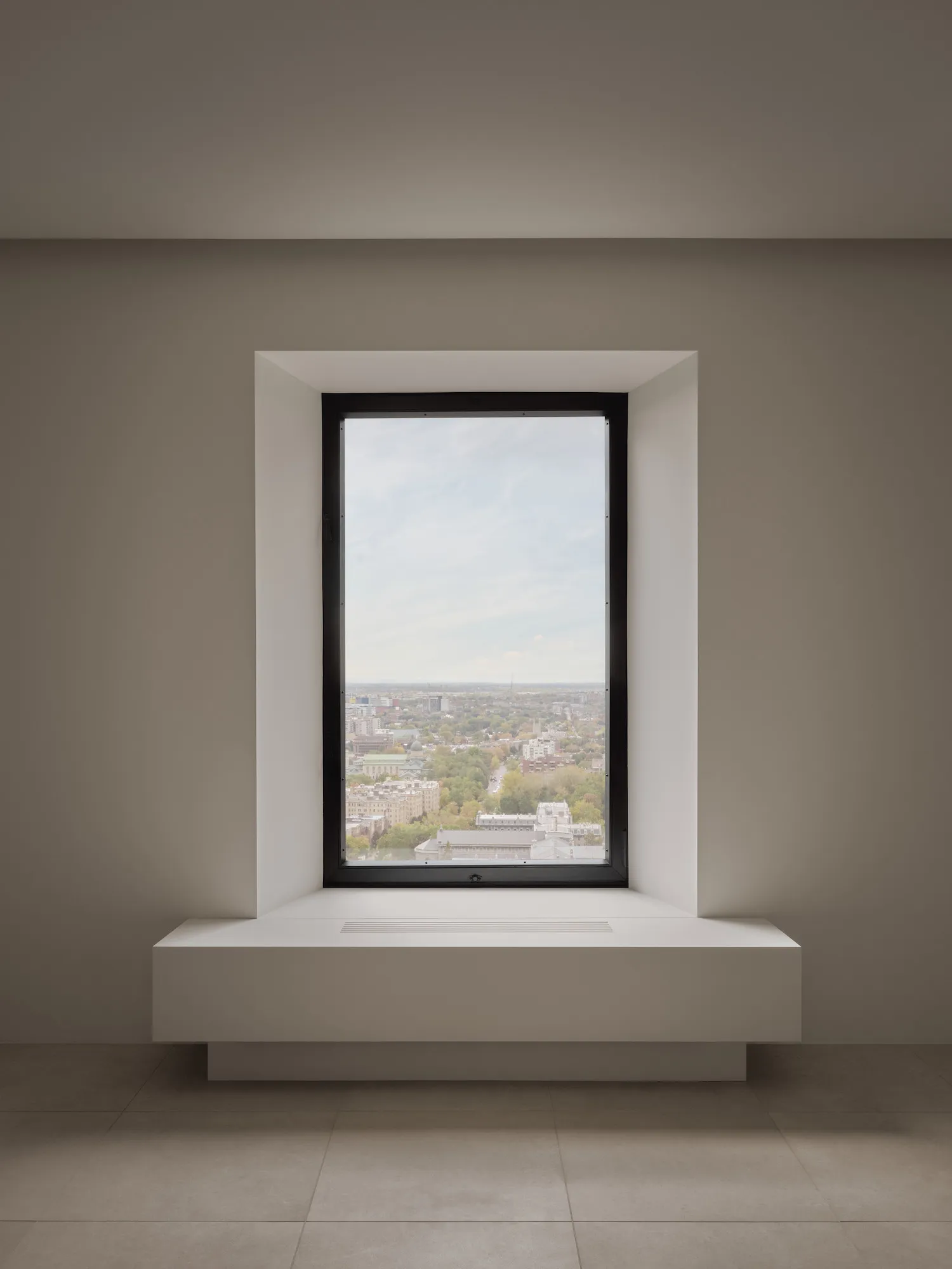 Modern window overlooking a cityscape with a metal frame.