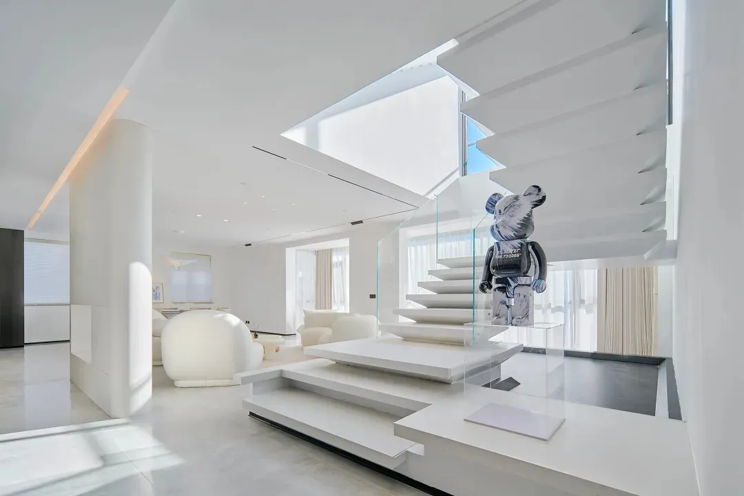 Modern minimalist interior with white marble floors, white lacquer cabinets, and glass railings.