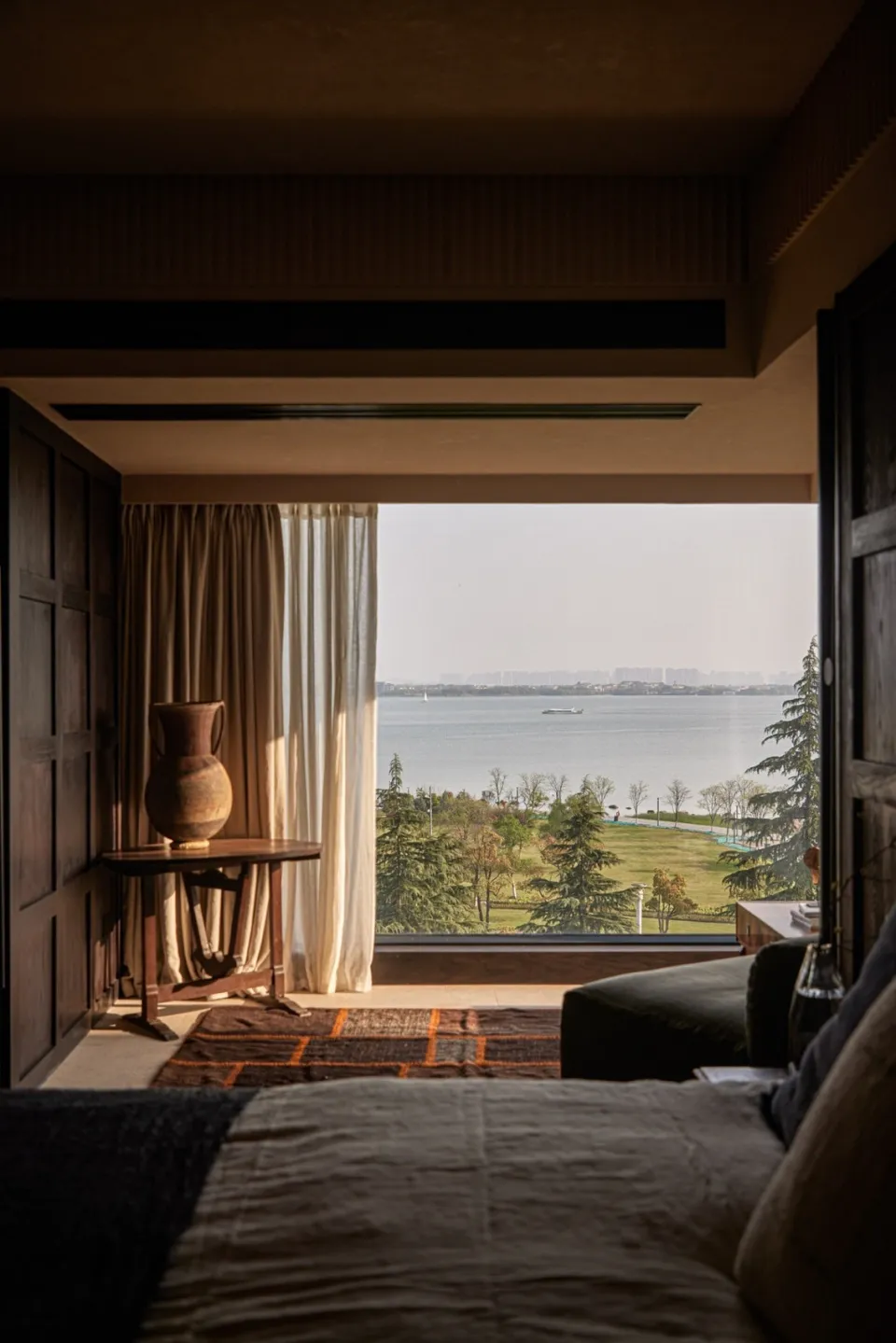 Modern residential bedroom featuring a bed with a water view.