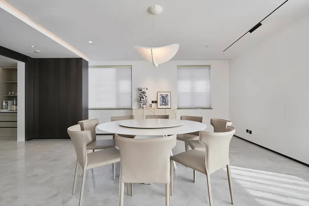 A contemporary living dining room with a white marble table and chairs.