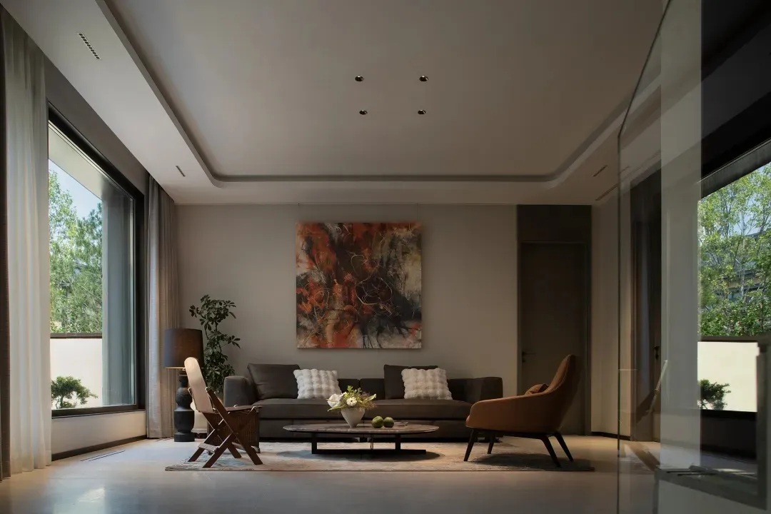 Modern living room with a contemporary sofa, chairs, and abstract art on the wall.