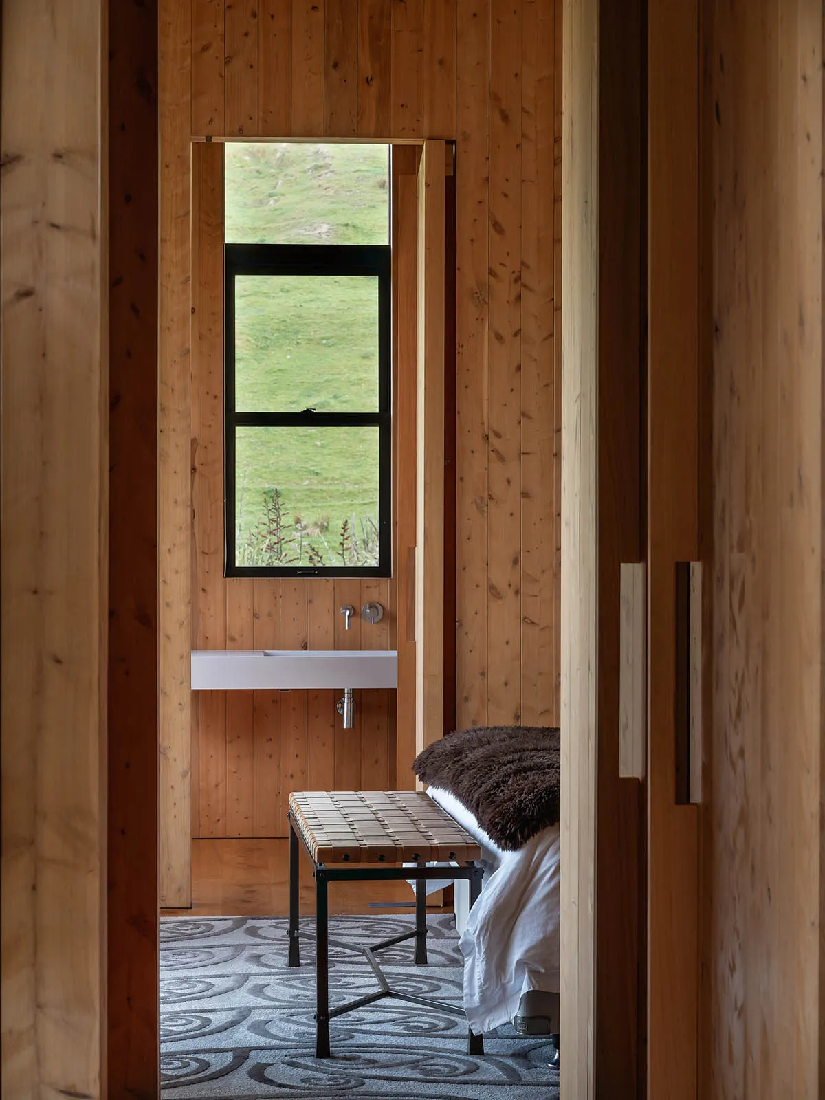 Minimalist bedroom featuring wooden elements and a simple, functional design.