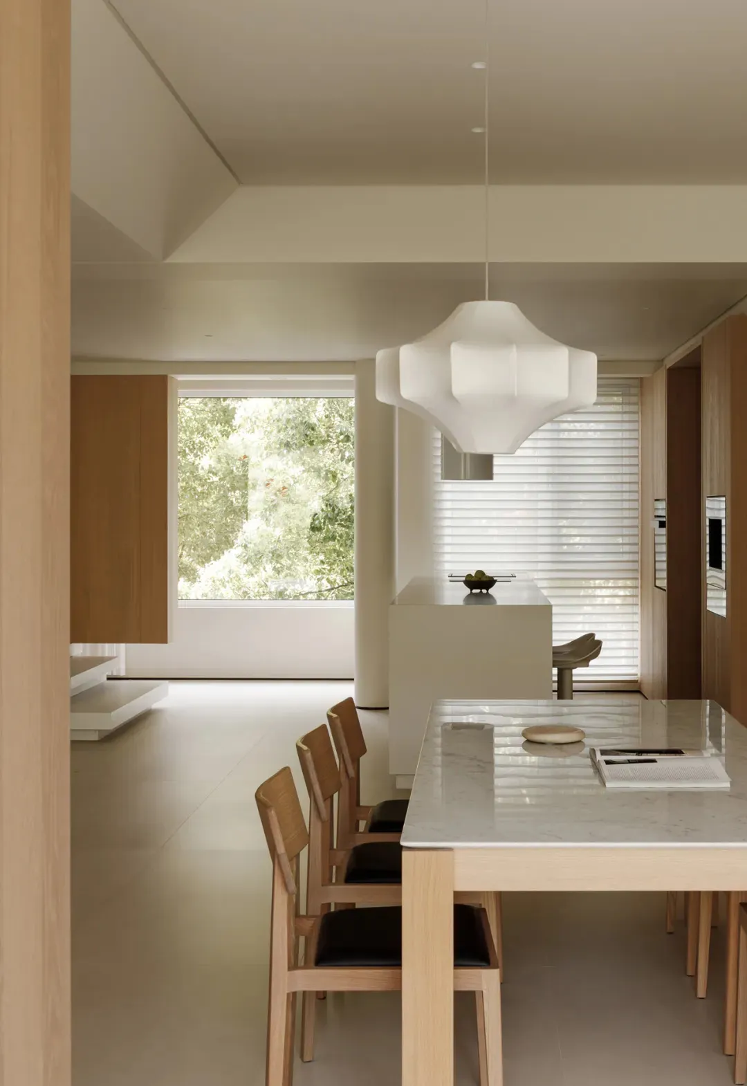 A modern kitchen featuring wood furniture and a marble countertop.