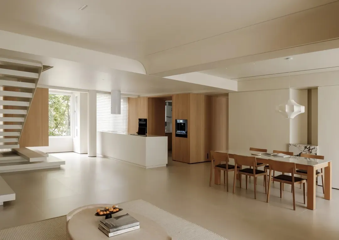 Modern kitchen and dining area with white and wooden furniture, minimalist design.