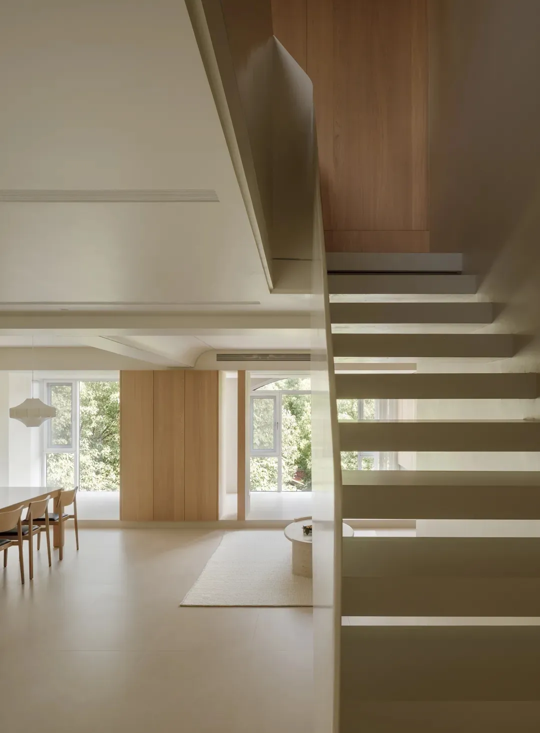 A modern interior space featuring minimalist design elements and wooden stairs.