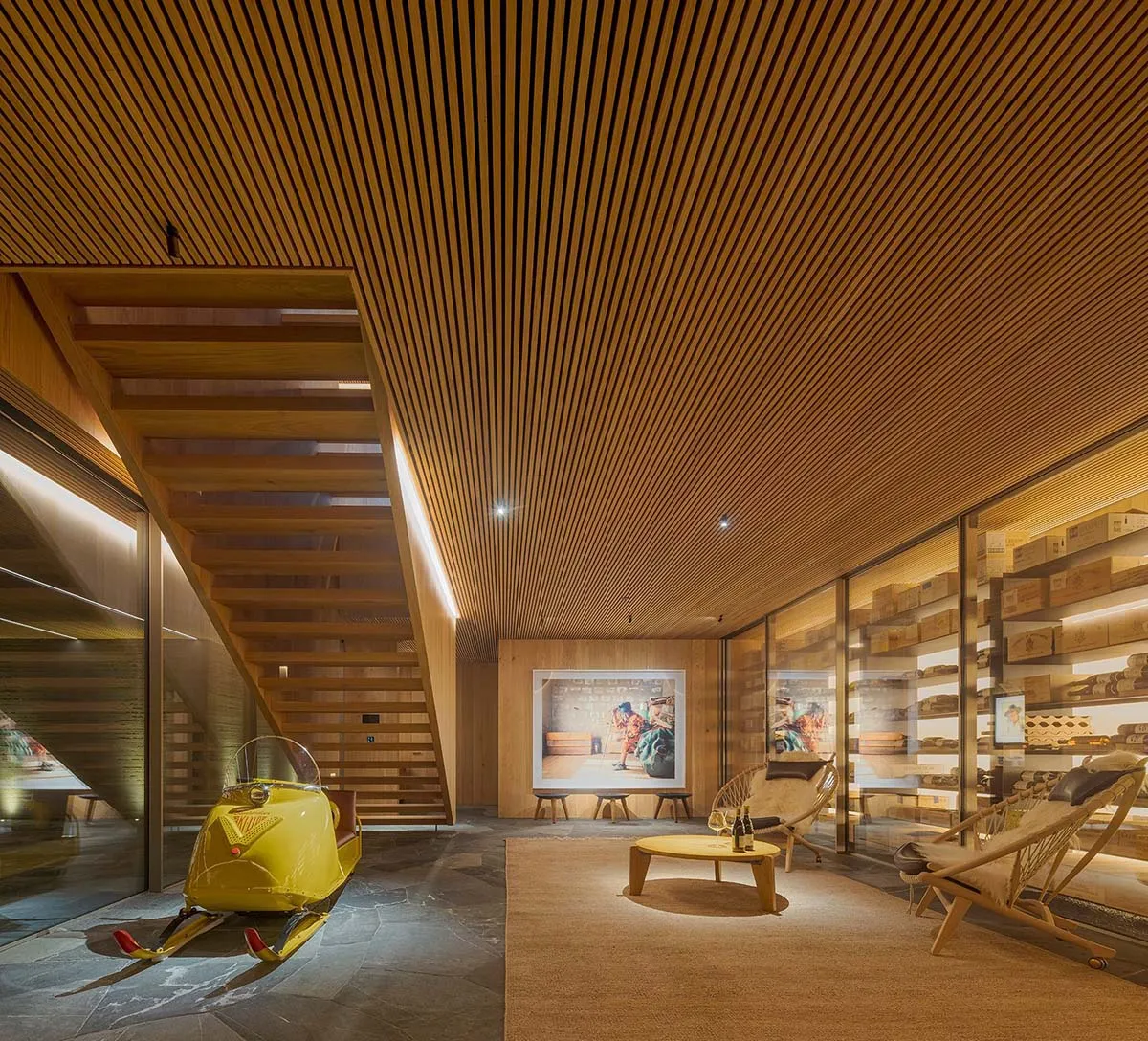 現代零售空間內部,採用木質飾面,並展示一輛黃色復古雪地摩托車。