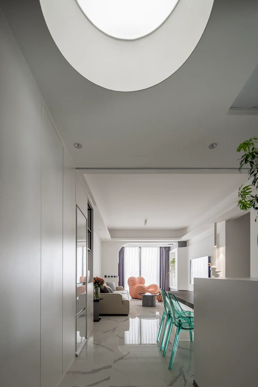 A modern living room featuring marble flooring and minimalist decor.