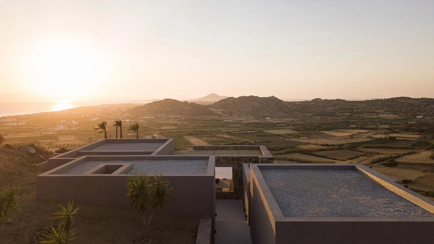 A minimalist residence featuring concrete architecture amidst a scenic landscape.