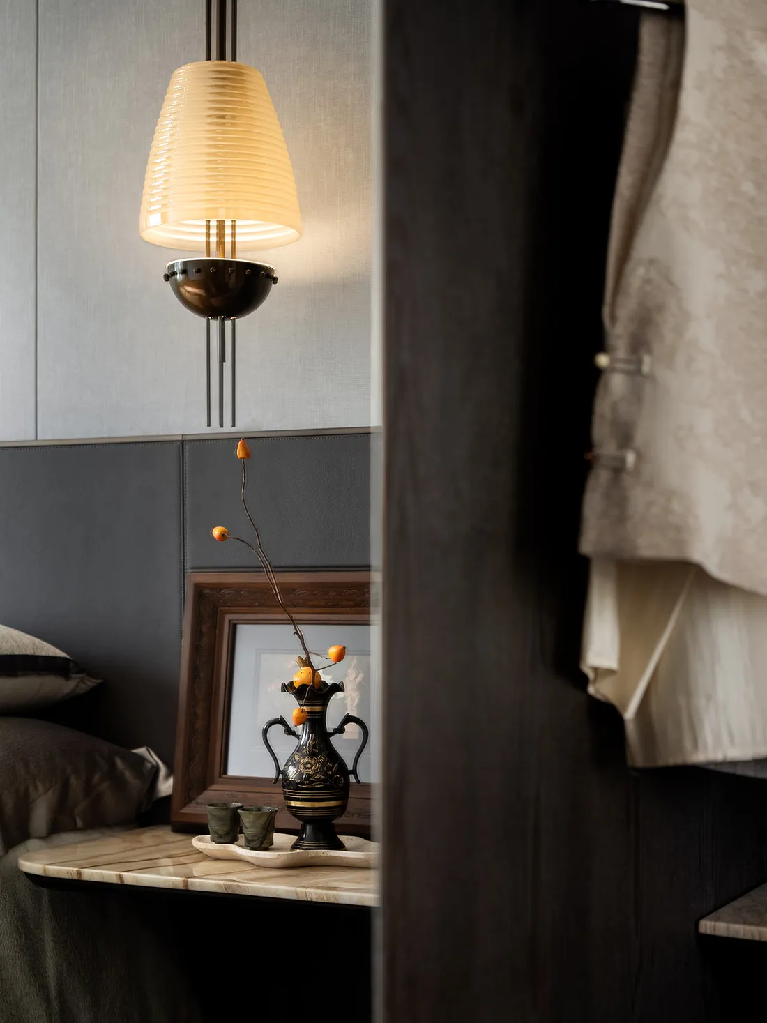 A modern bedside table with a vase and fruit on it.
