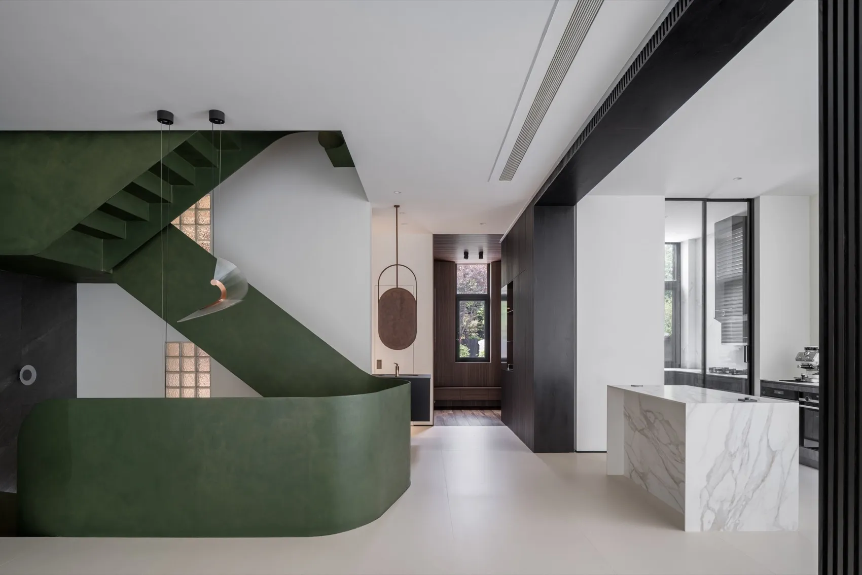 Modern residential interior design featuring marble countertops, black wooden cabinets, and green metal accents