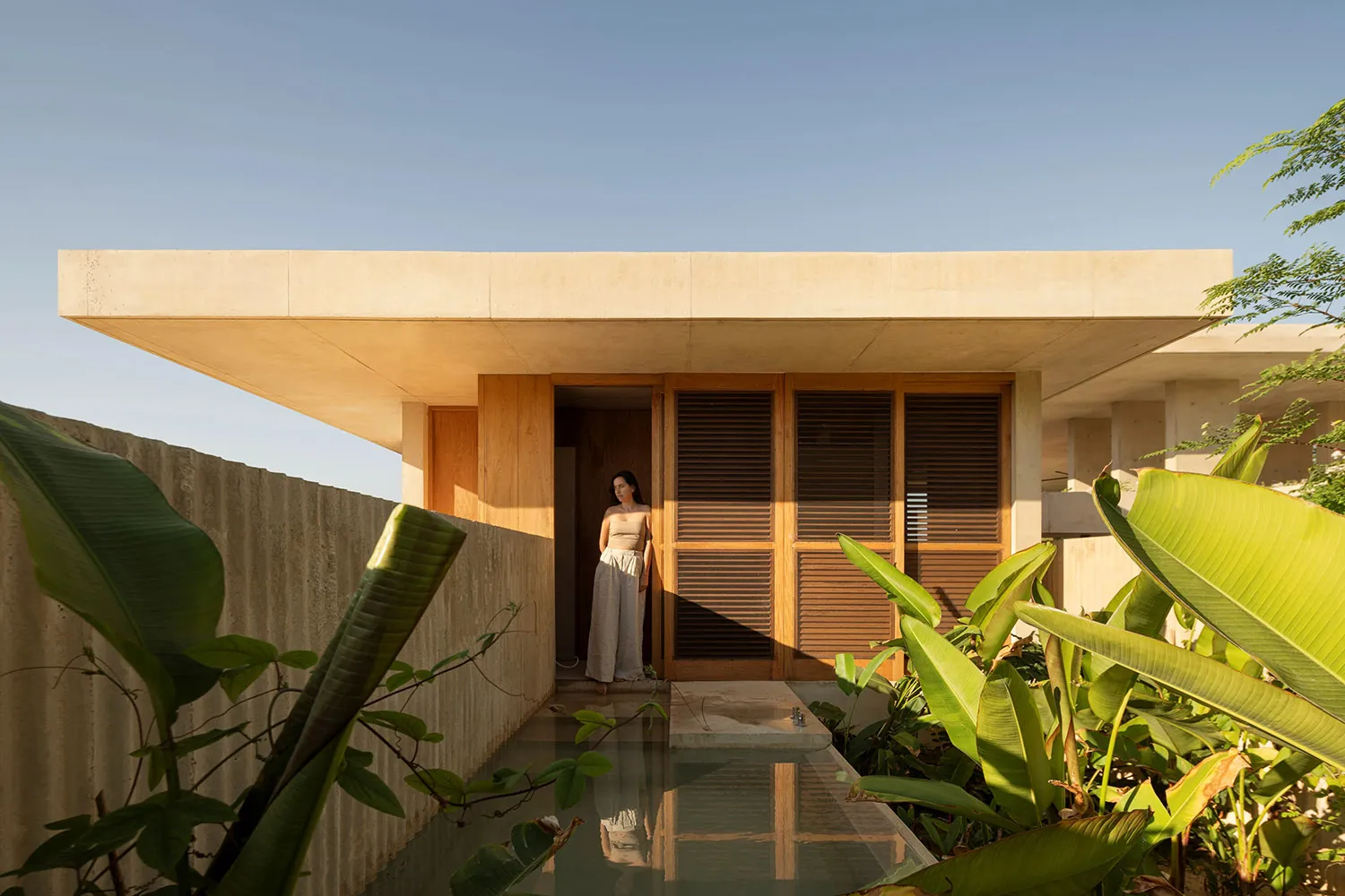 A minimalist residential structure featuring concrete and wood materials.