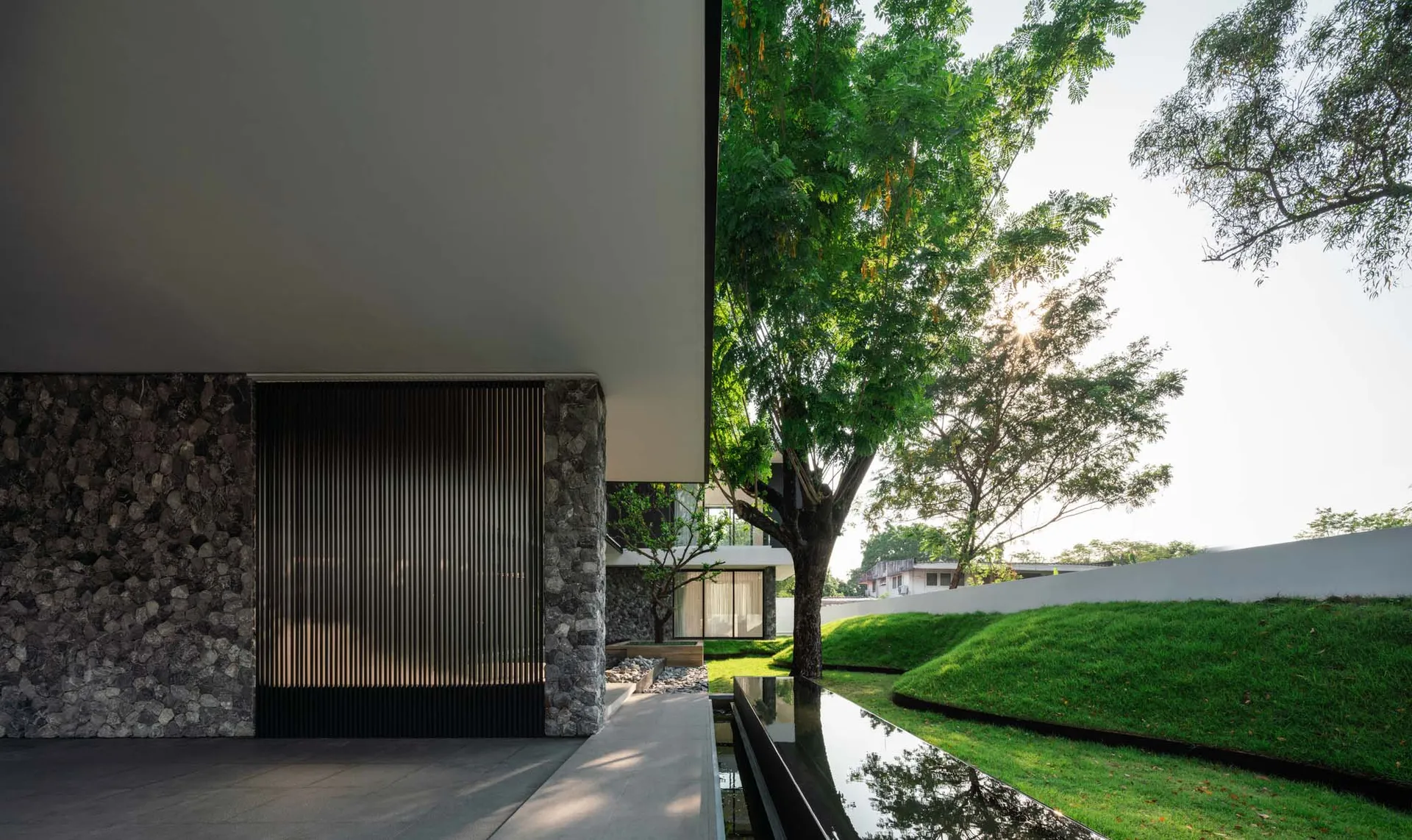 A modern residential facade featuring glass and stone materials.