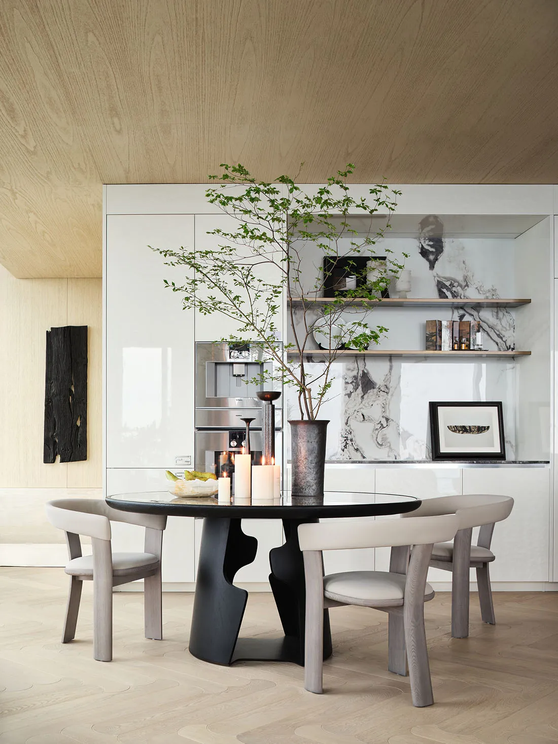 Modern residential kitchen featuring marble countertops, wooden cabinets, and elegant furniture.
