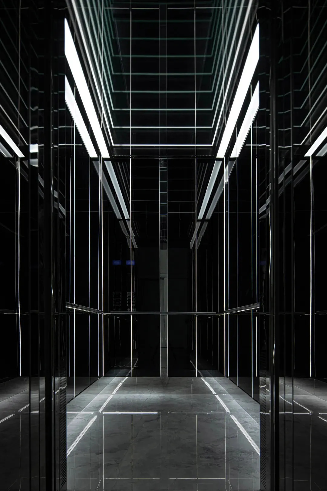An empty minimalist lobby with black steel walls and floor.