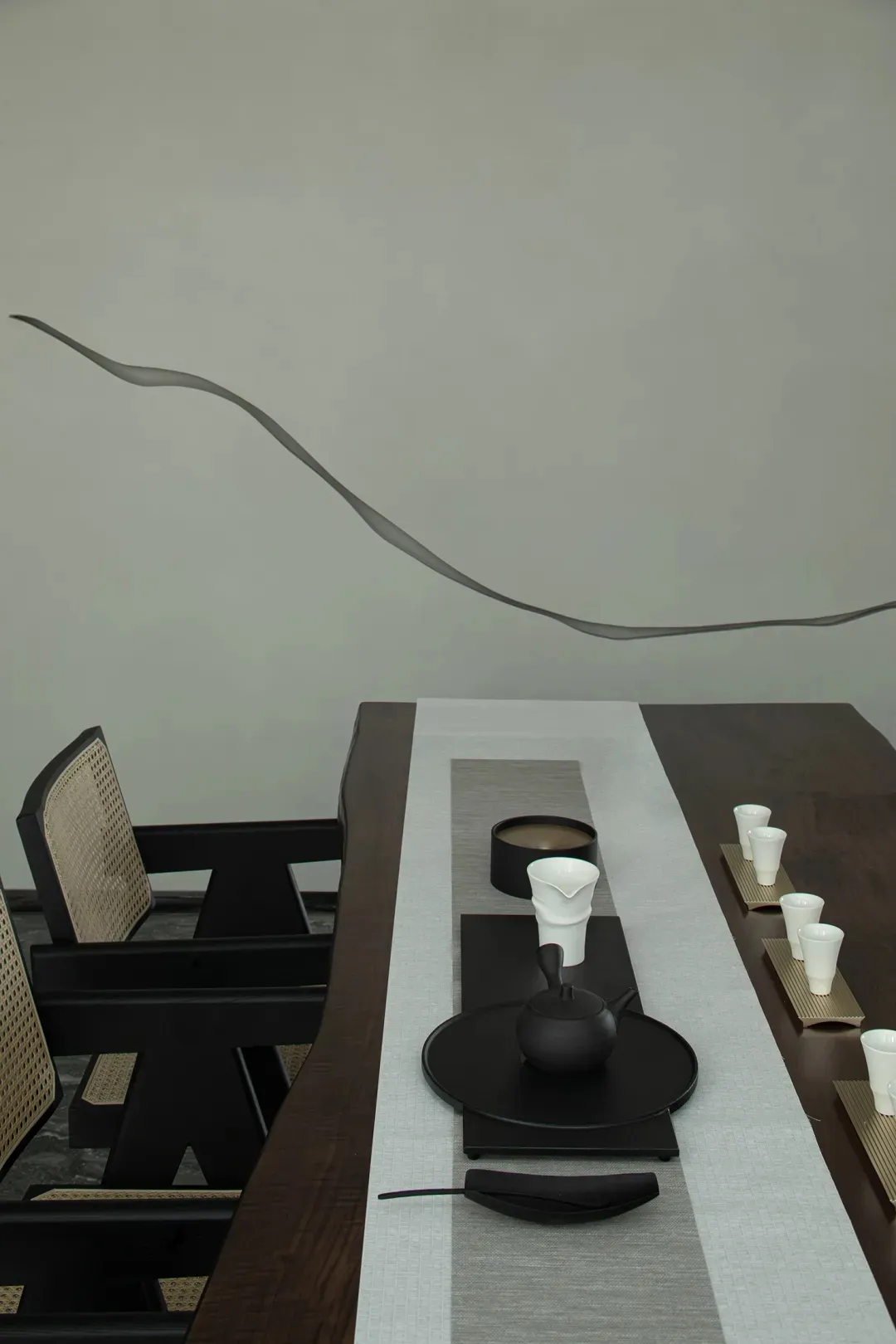 A modern tea room featuring minimalist furniture, wooden table, and white accessories.