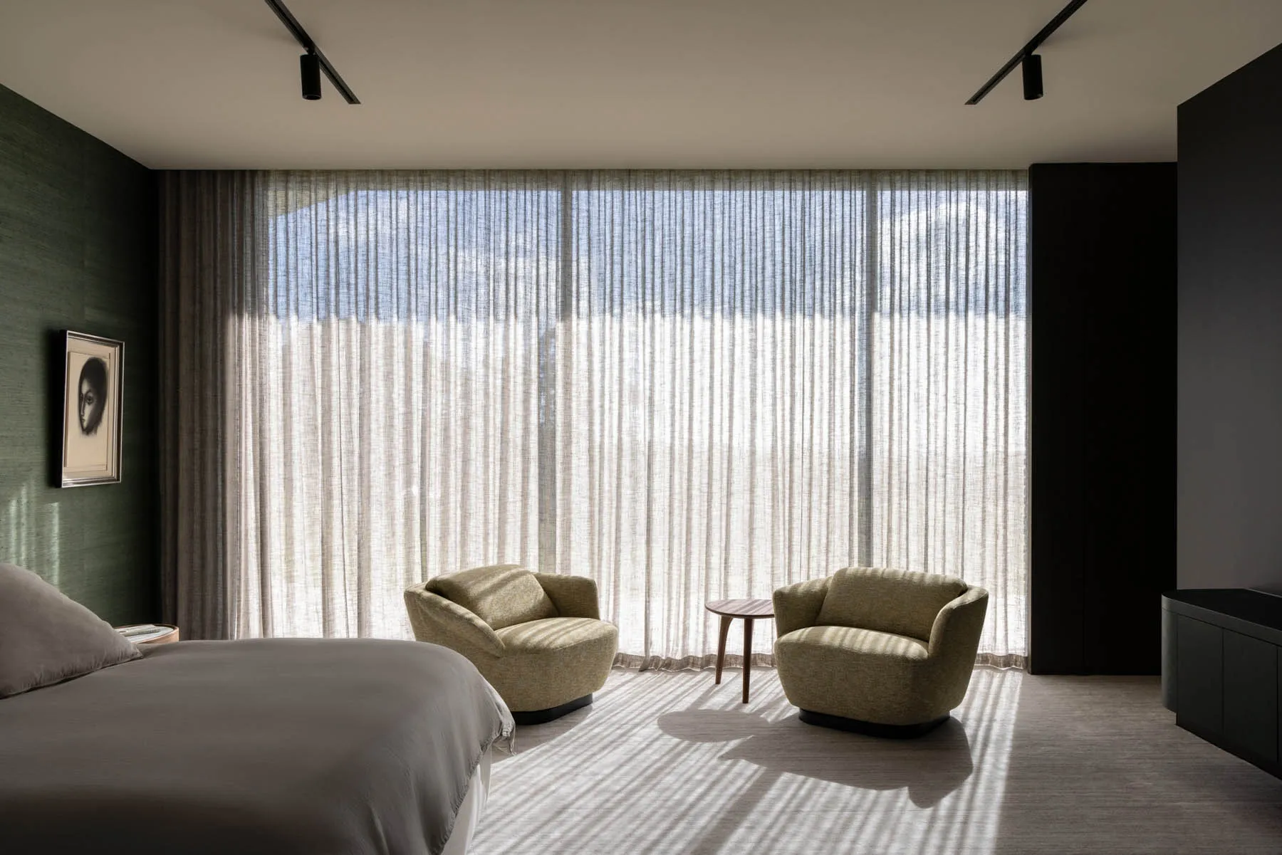Modern bedroom featuring fabric furniture and glass windows.