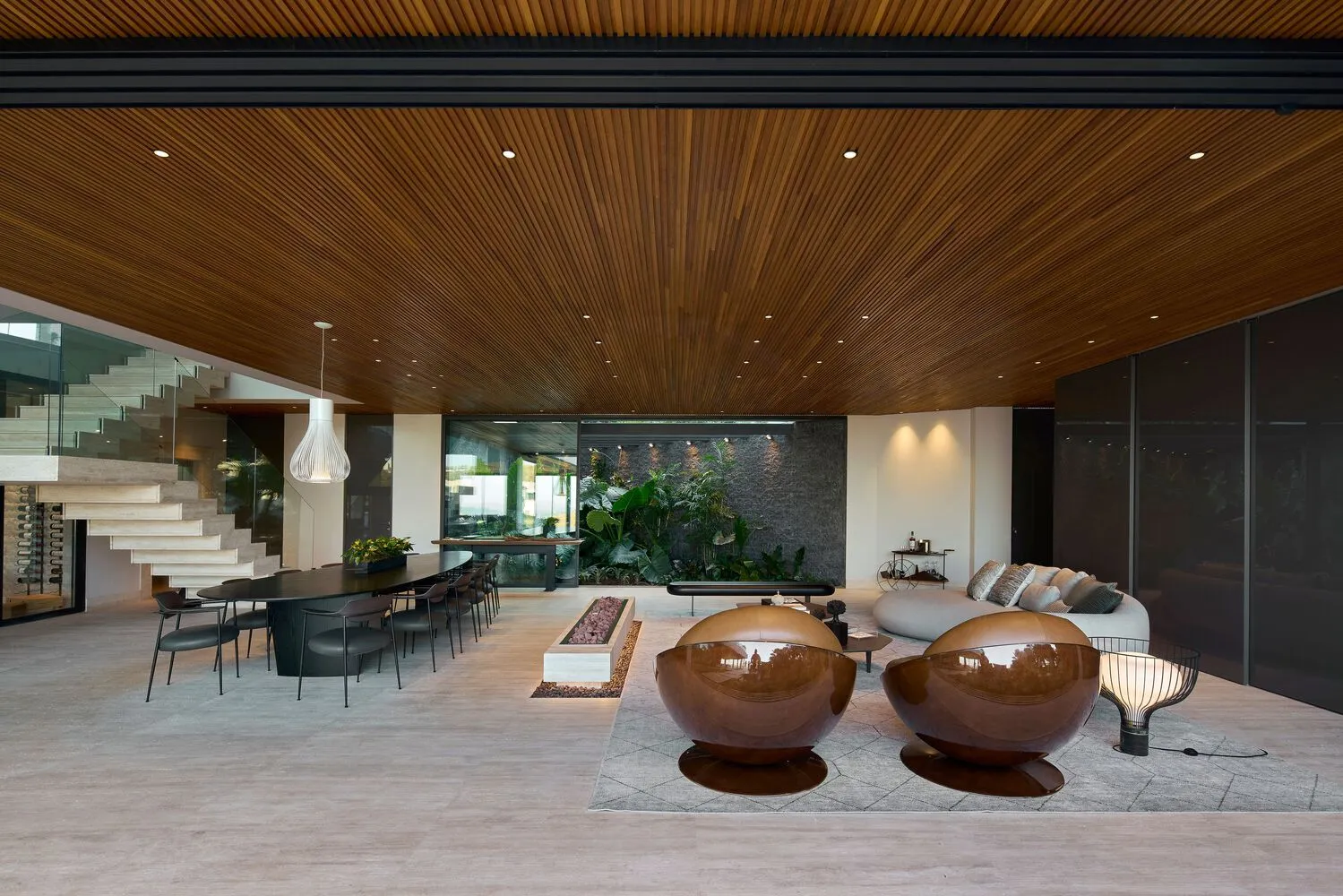 Modern living room with wooden ceiling, glass elements, and minimalist design.