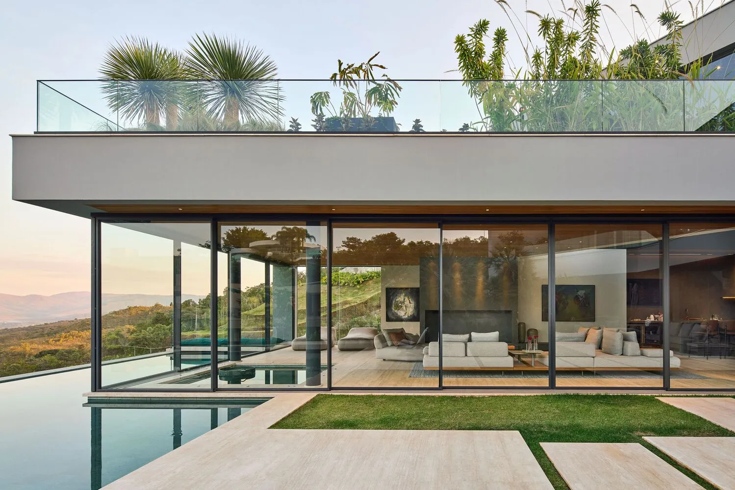 Modern residential exterior featuring glass, concrete, and metal materials.