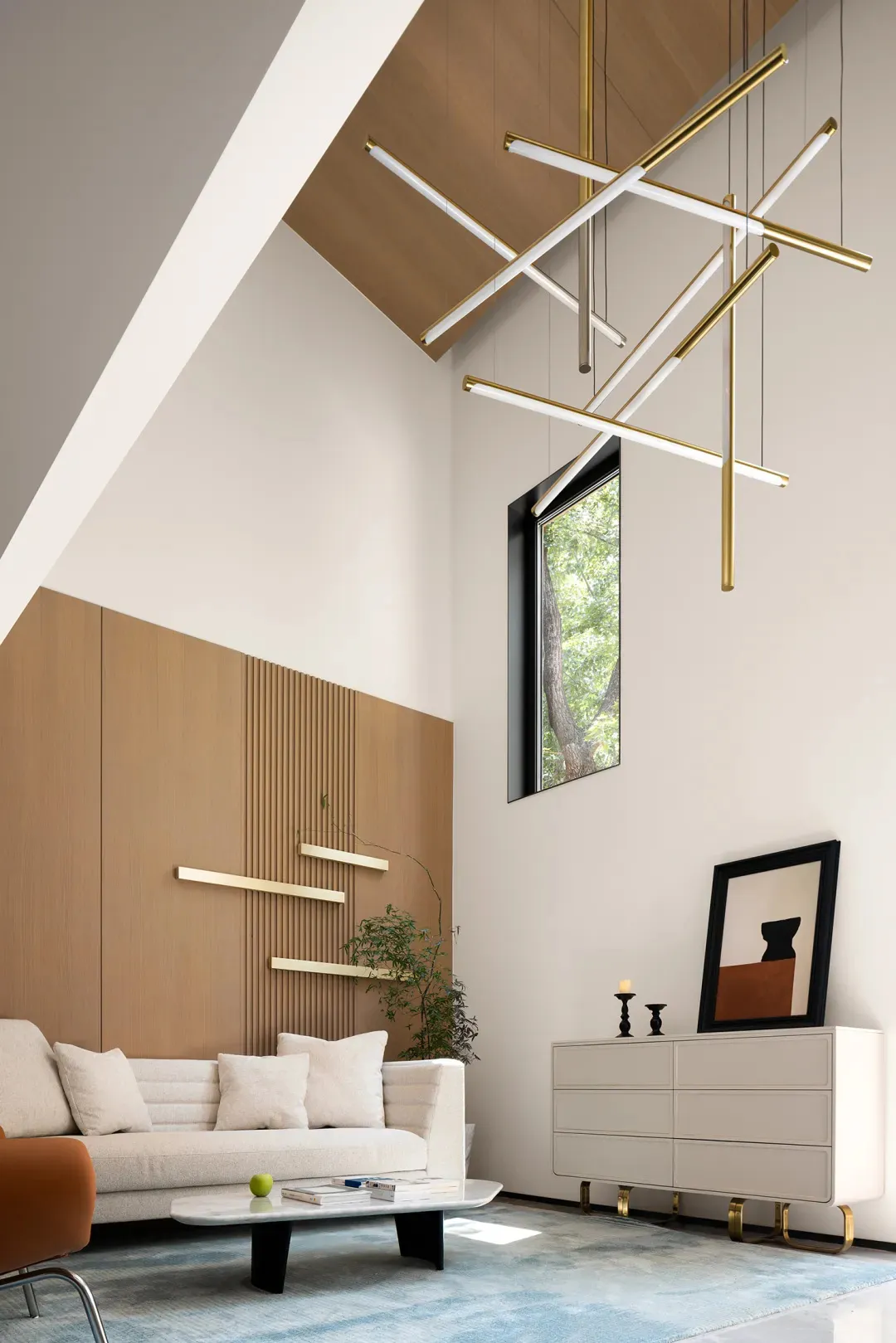 A modern living room featuring minimalist design, white sofa, brass lighting fixtures, and a large window.