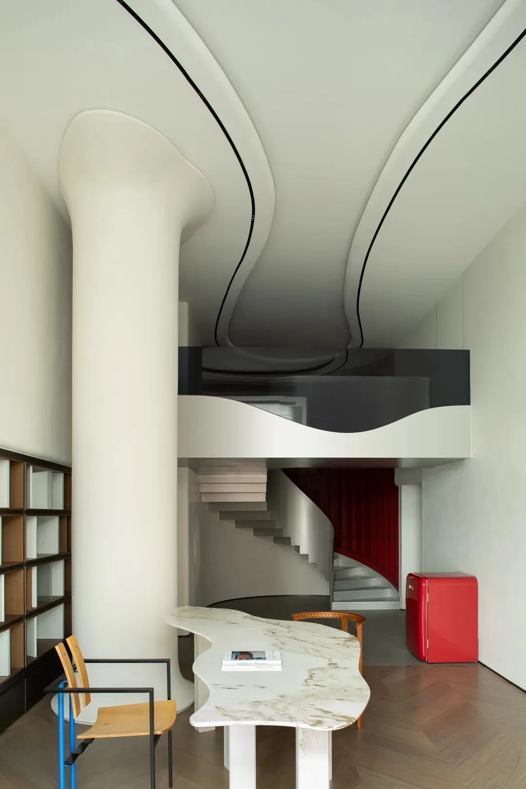 Modern residential interior featuring marble surfaces, red fabric, and wood elements.