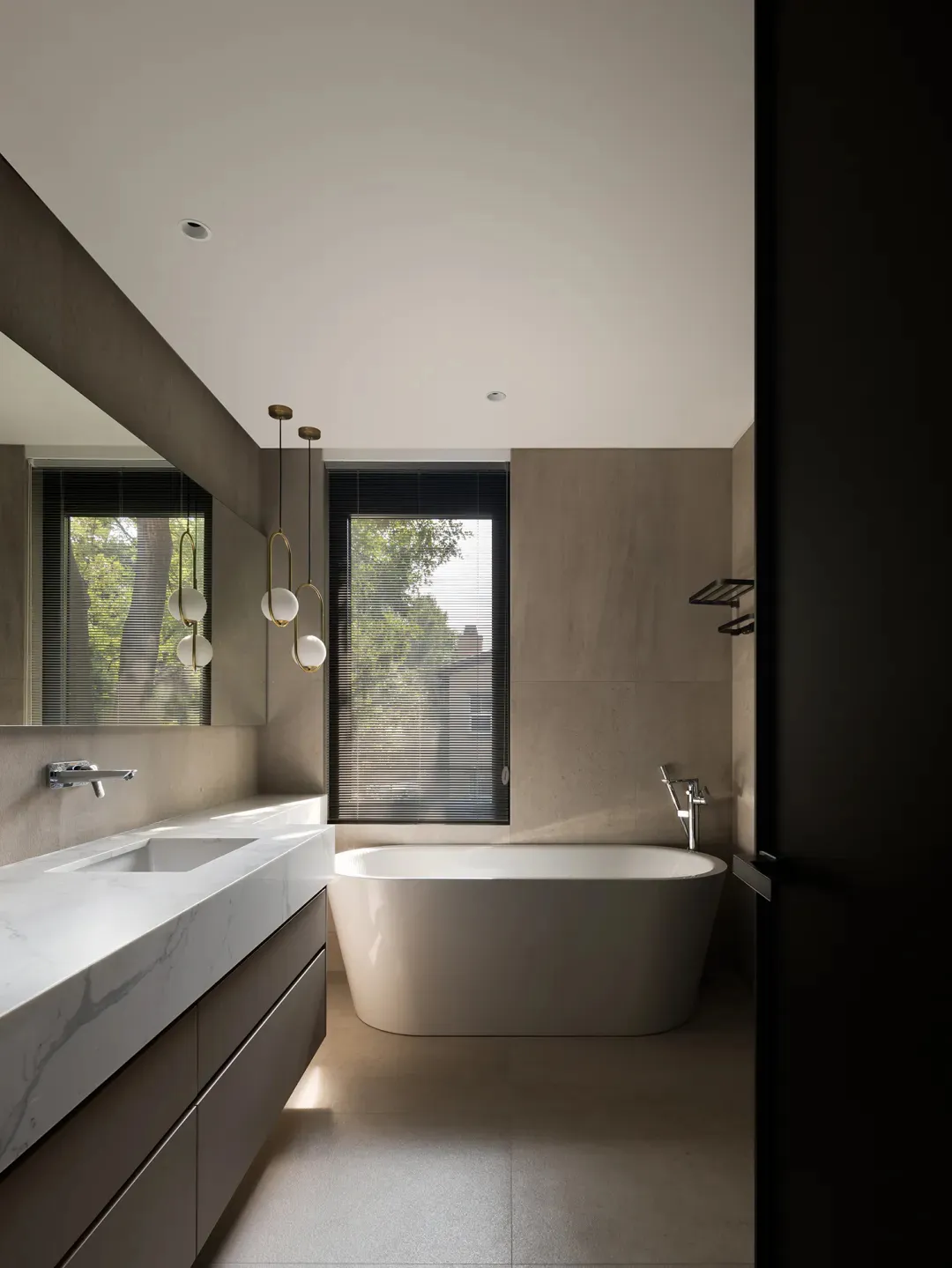 Modern minimalist bathroom featuring a freestanding bathtub with concrete walls and a glass window.
