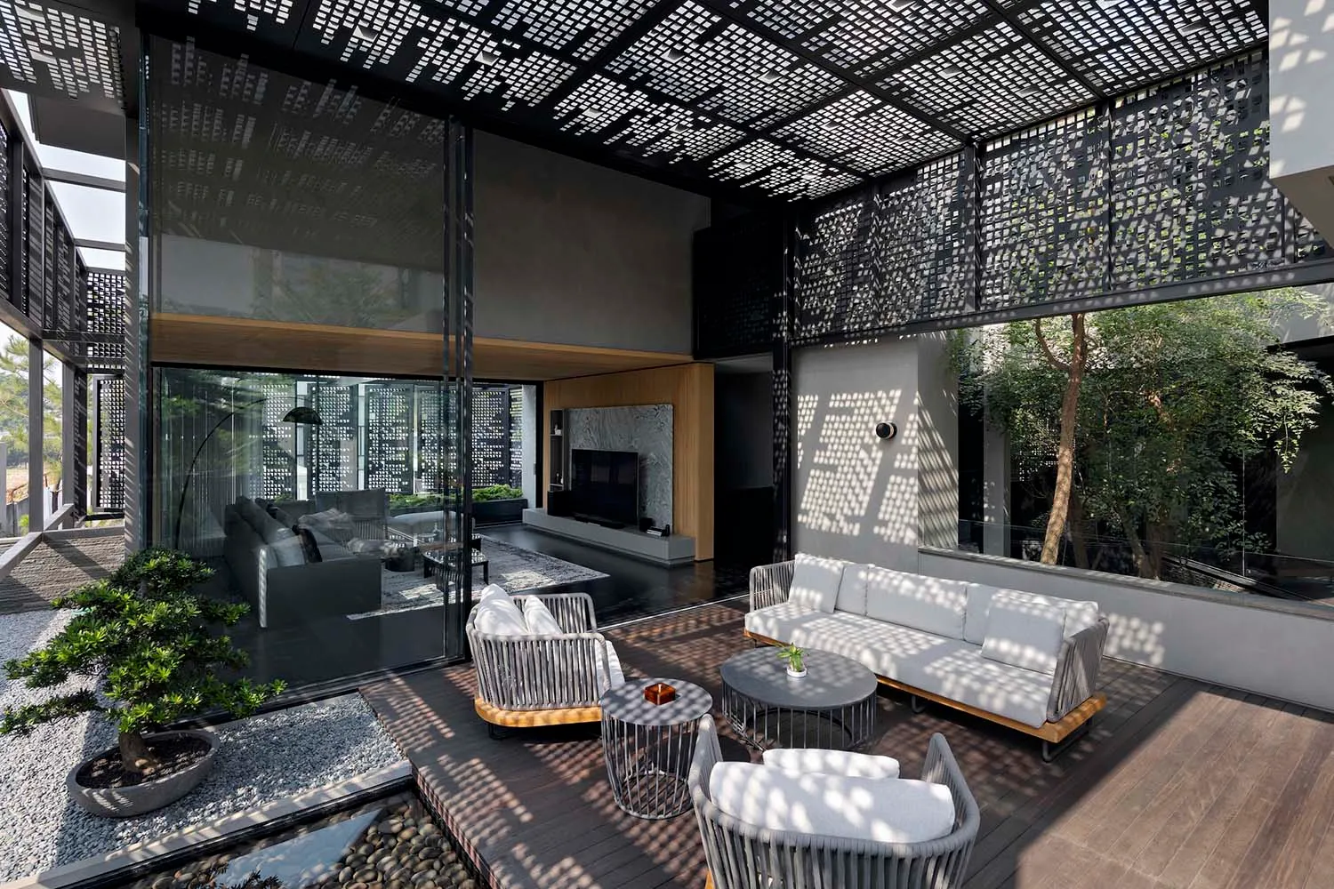 Modern, minimalist outdoor patio area with a wooden deck, white furniture, and potted plants.