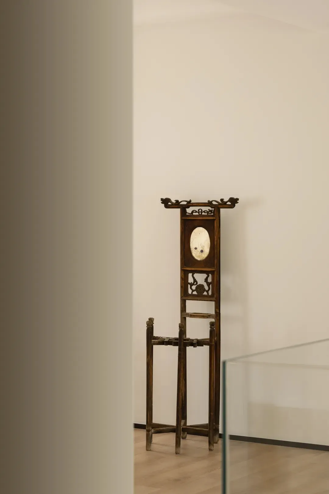 An antique wooden cloakroom rack with intricate carvings and a mirror in the center.