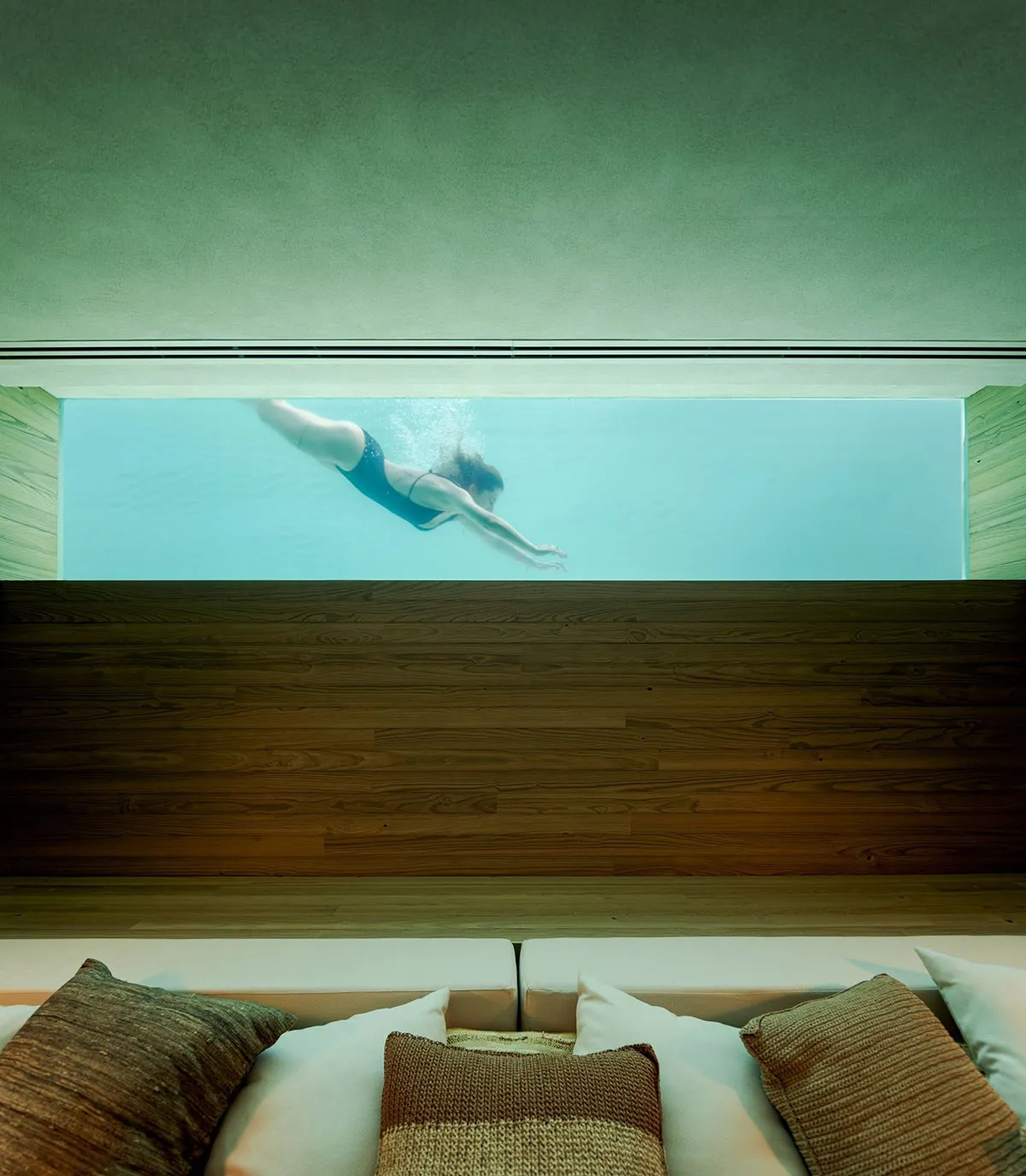 An empty swimming pool view through a window with a minimalist design setting.