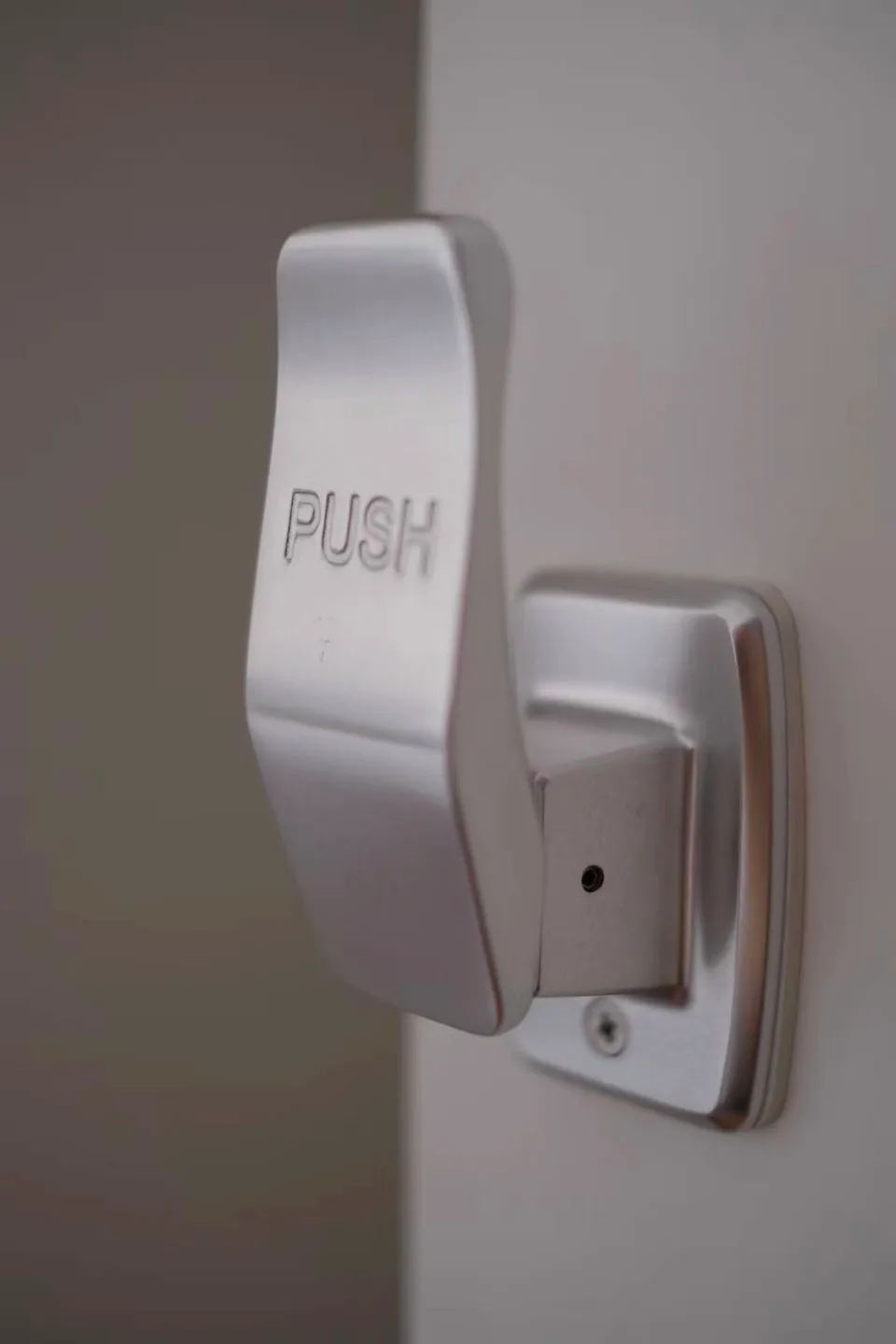 銀色金屬按壓式把手，上面刻有「PUSH」字樣