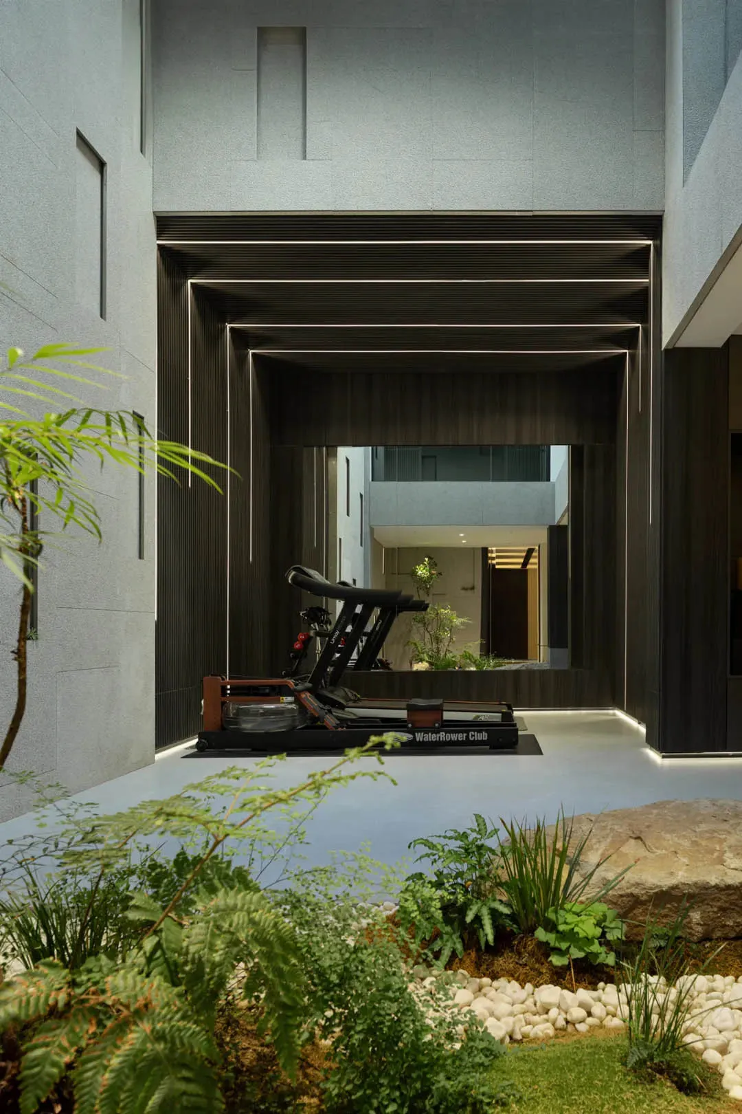 Modern gym area with metal frame, glass wall, and stone floor