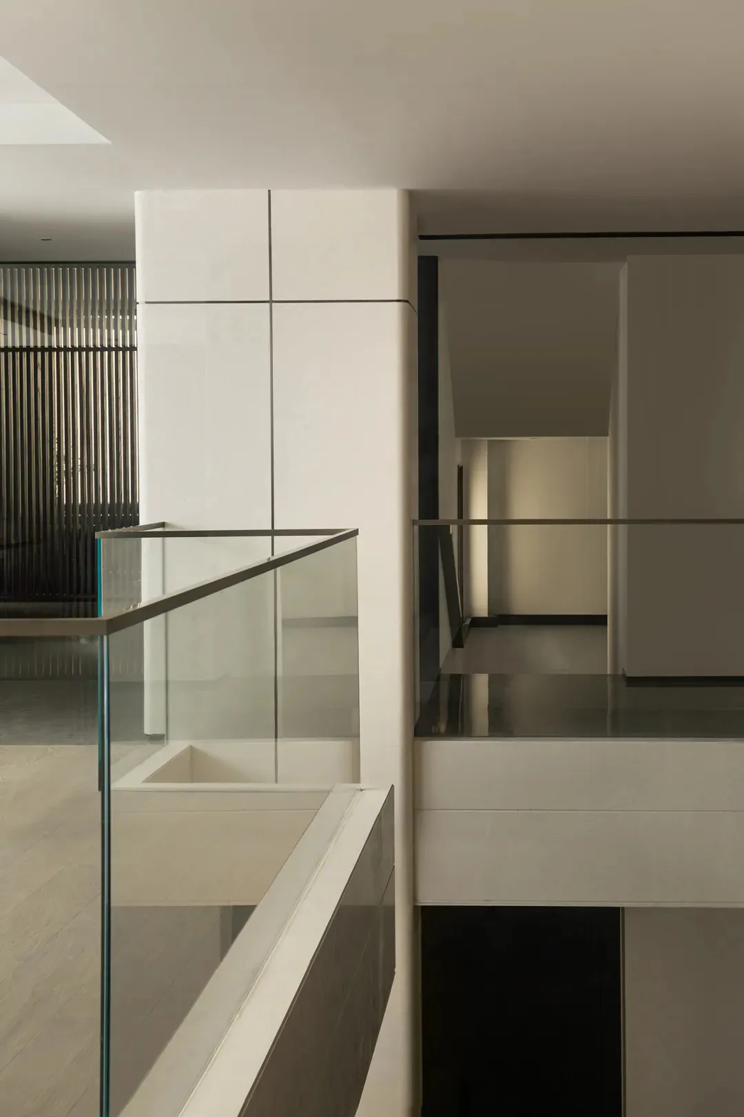 Modern interior with glass walls and stairs in a minimalist design.