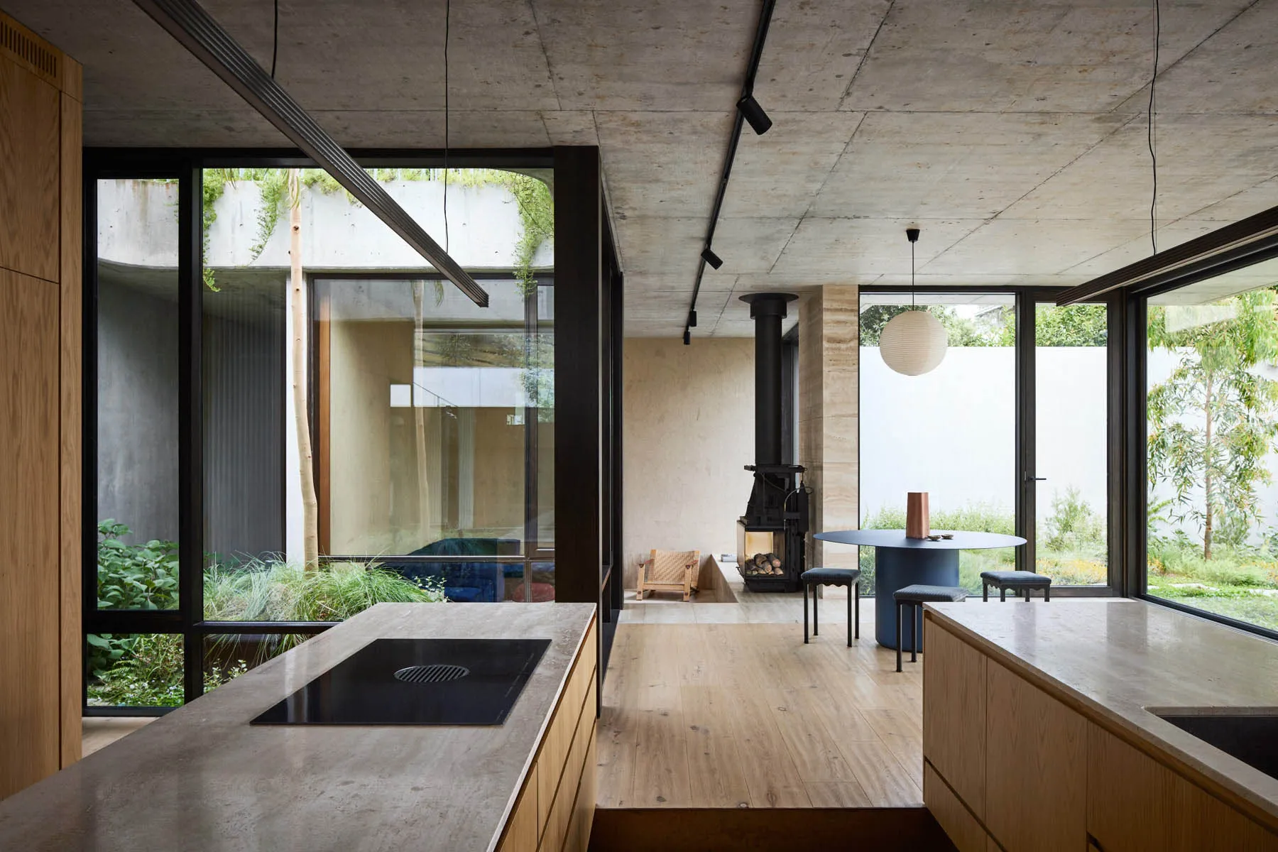A modern kitchen and living space featuring concrete materials and industrial design elements.