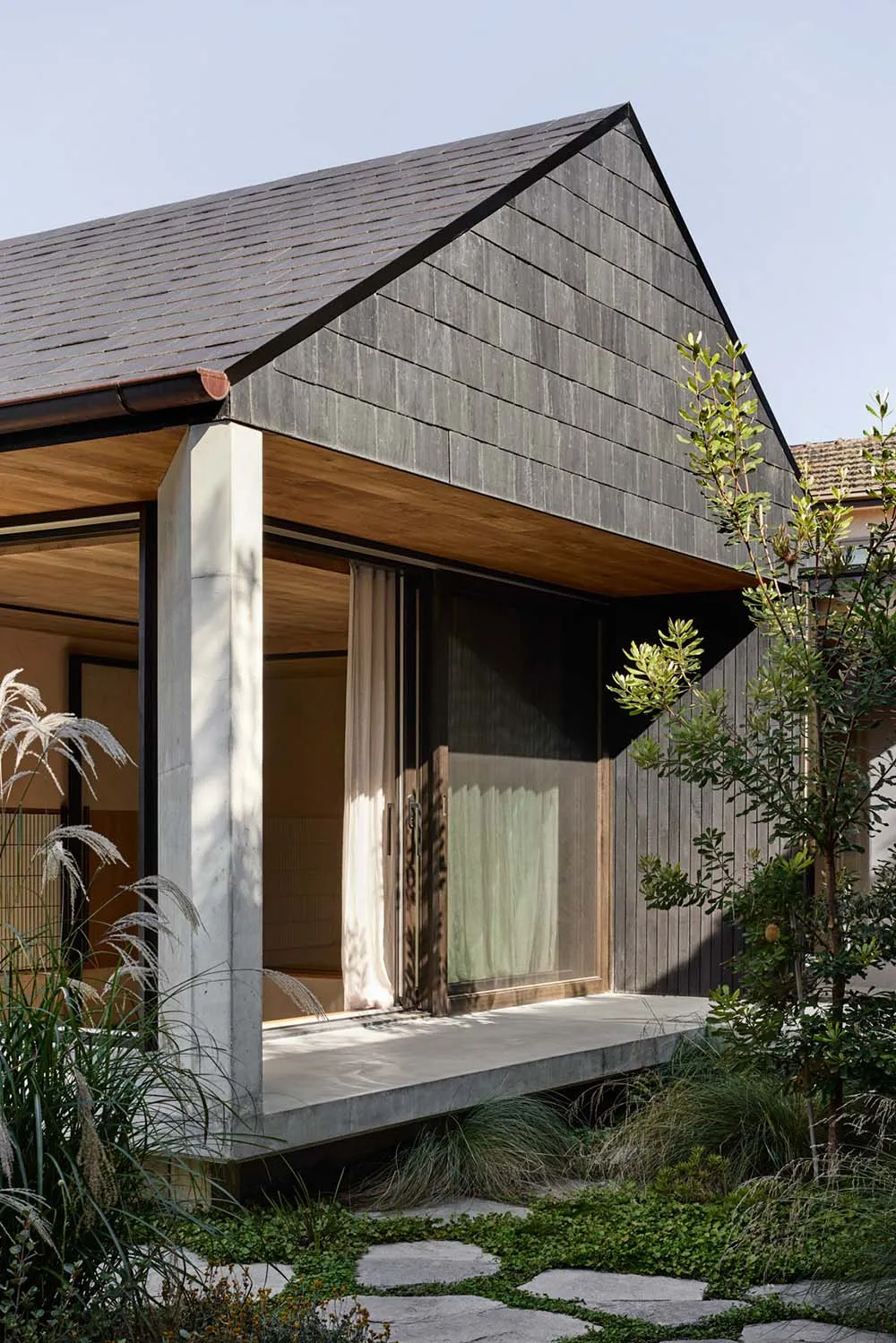 A modern residential house featuring wooden shingles and concrete.