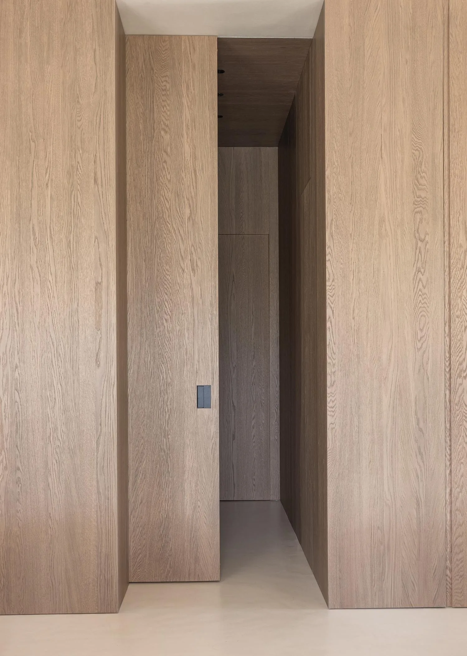 A modern minimalist interior featuring wooden walls and a clean, straight hallway.