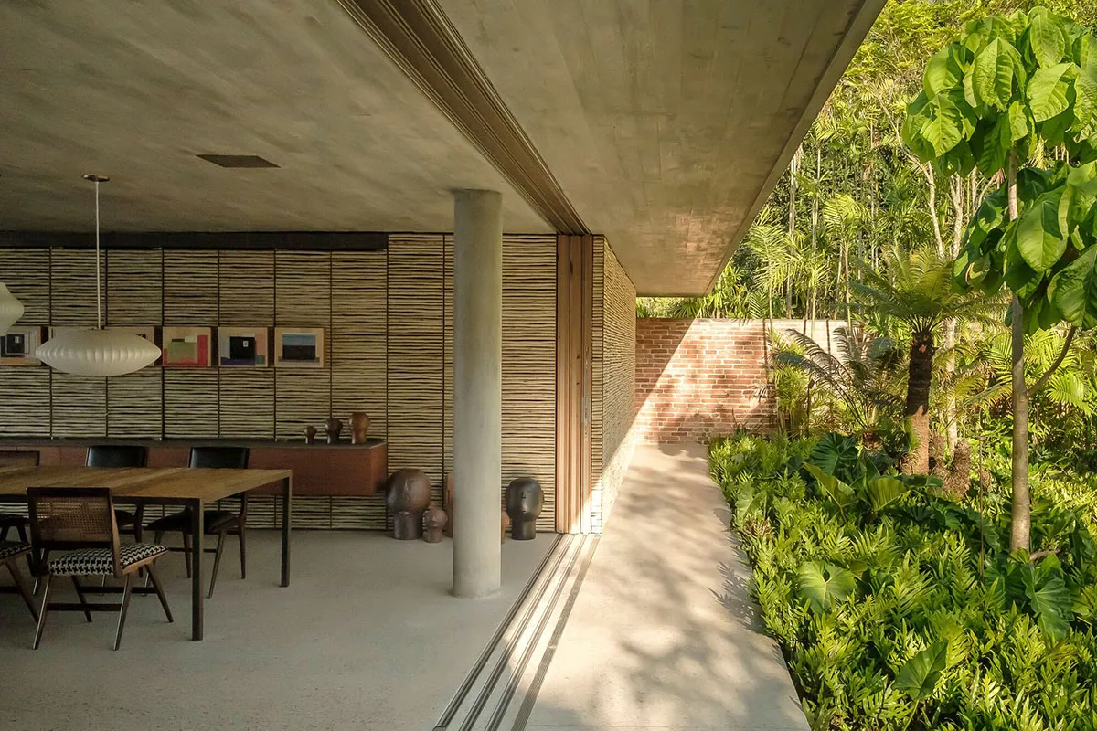 A modern interior design featuring concrete, brick, and wooden elements with outdoor access.