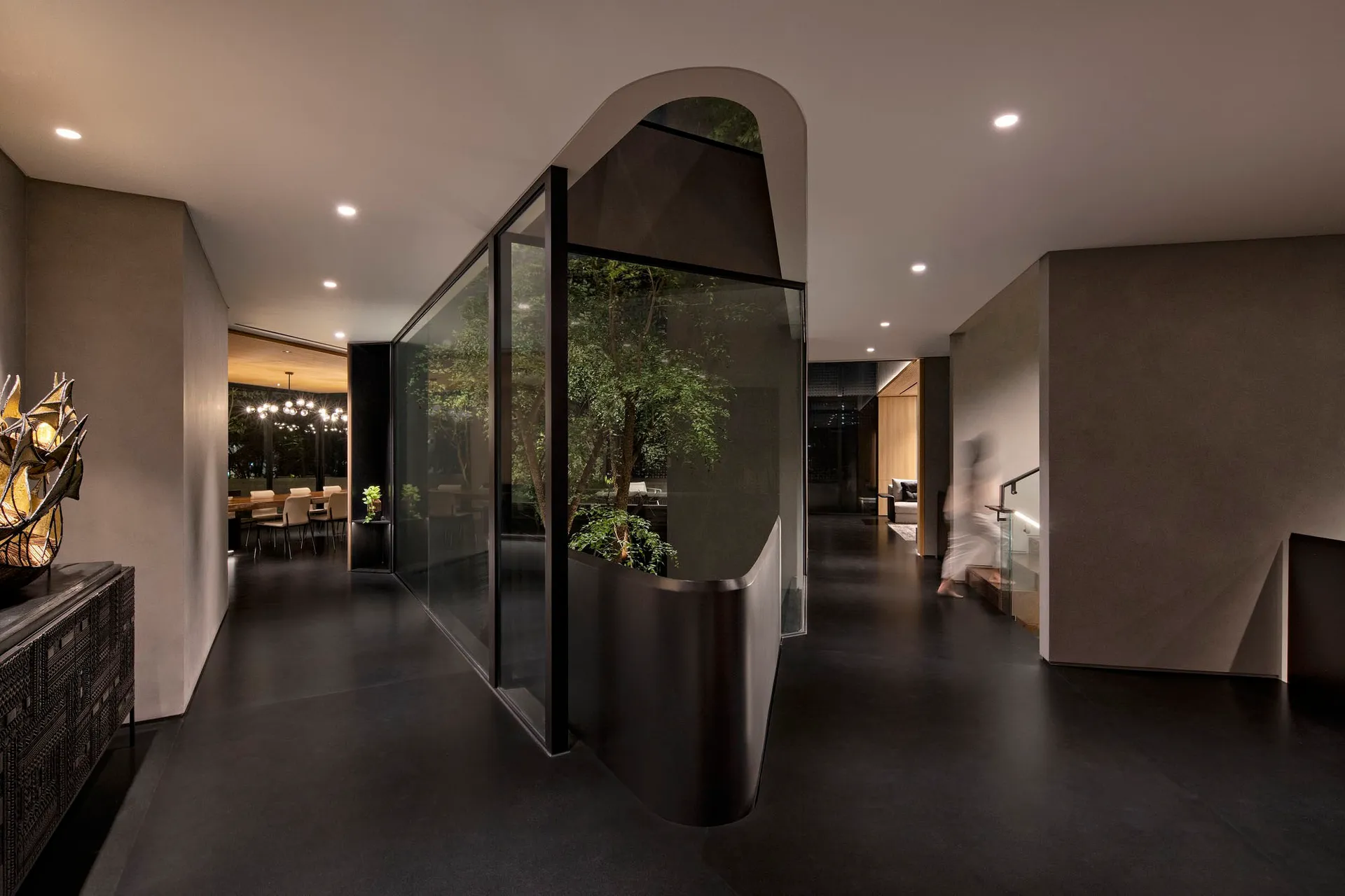 Modern minimalist living room with concrete walls and glass walls.