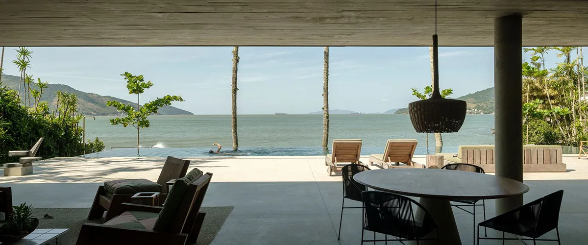 Minimalist vacation resort living room with concrete and glass elements.