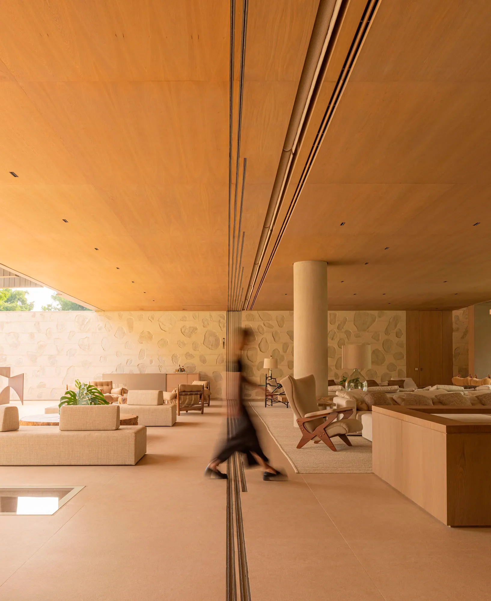 Modern living room with wooden paneling, featuring minimalist furniture and natural light.