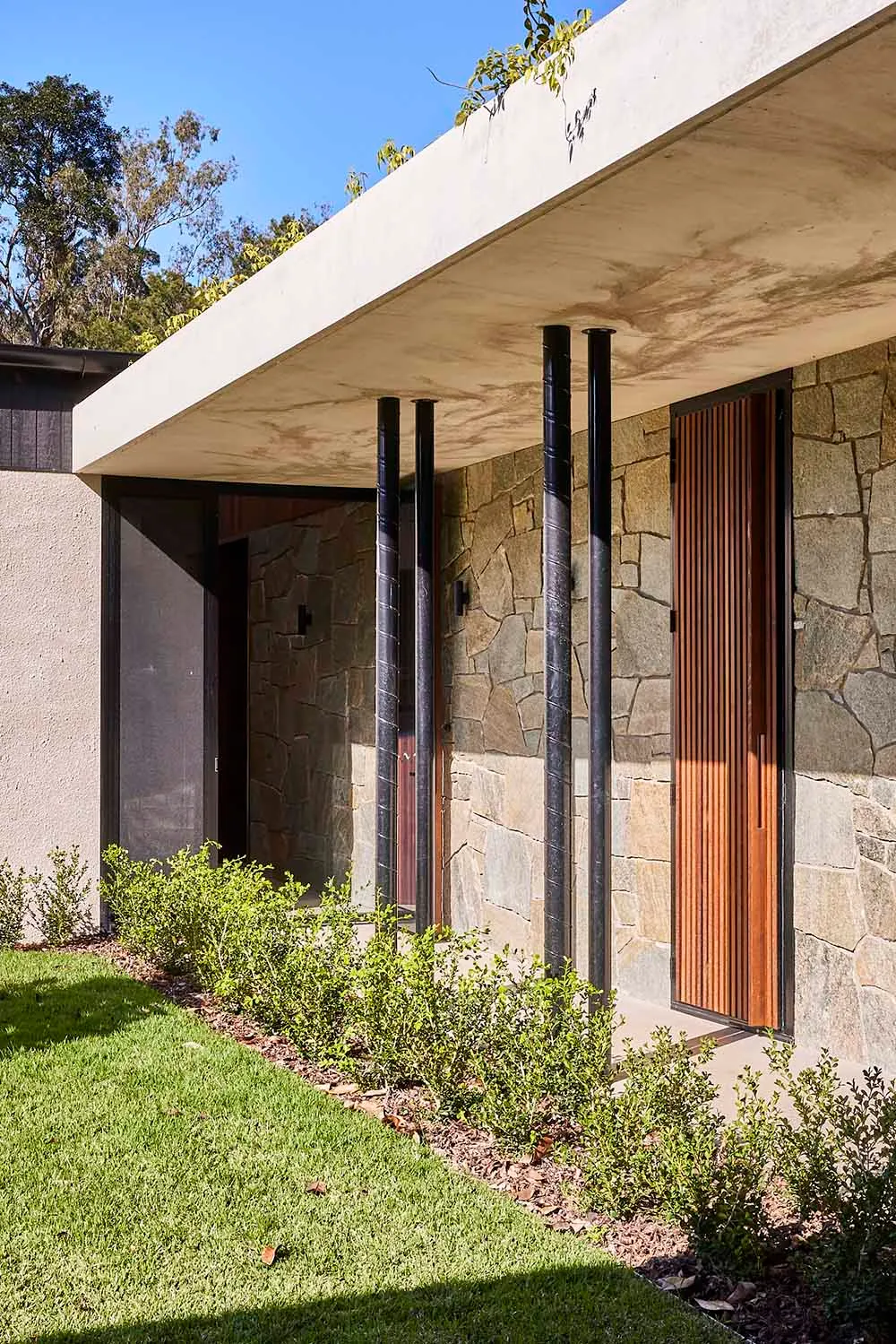 Modern exterior entrance with stone and concrete materials.