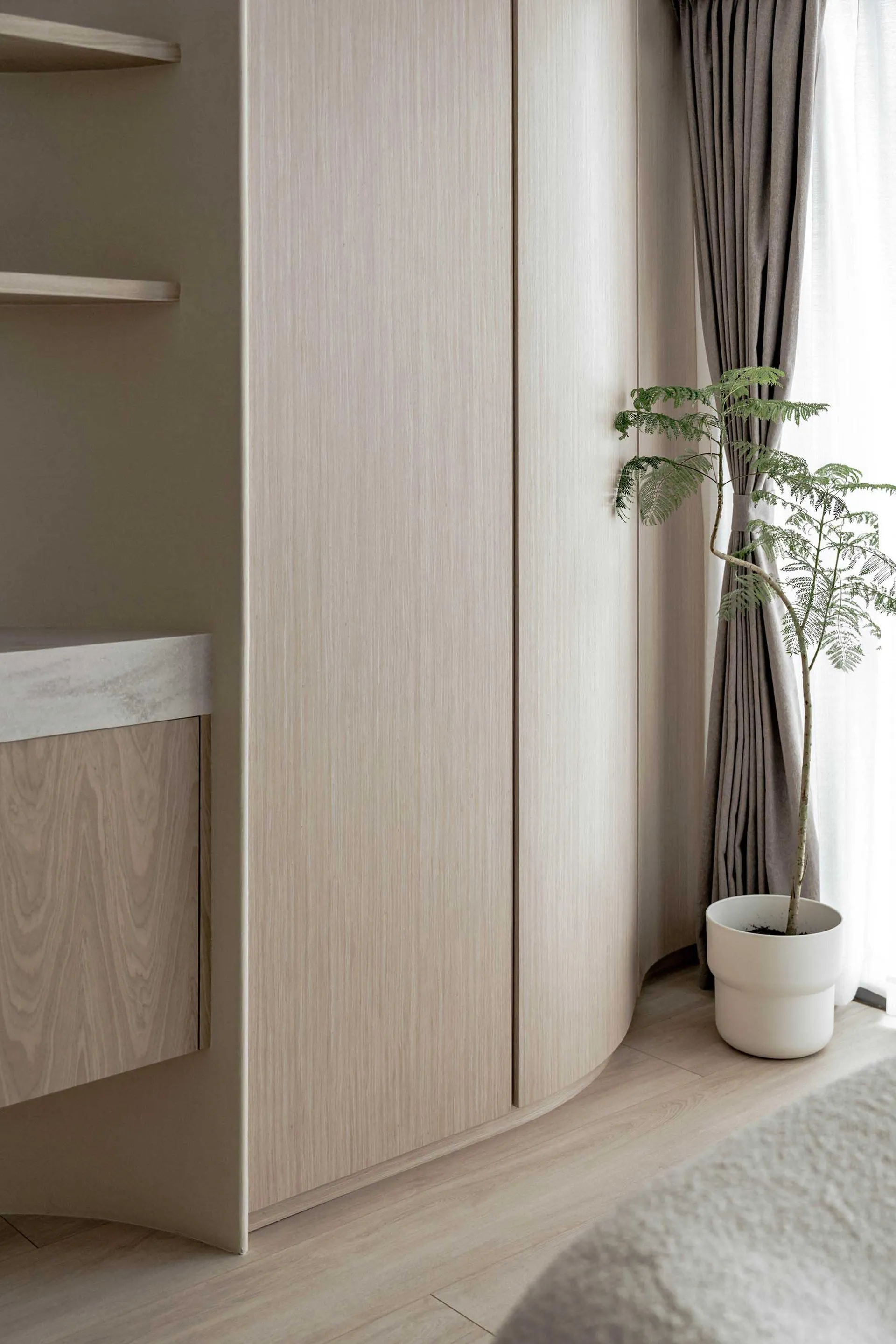 Modern minimalist interior design featuring wooden cabinets and a small plant.