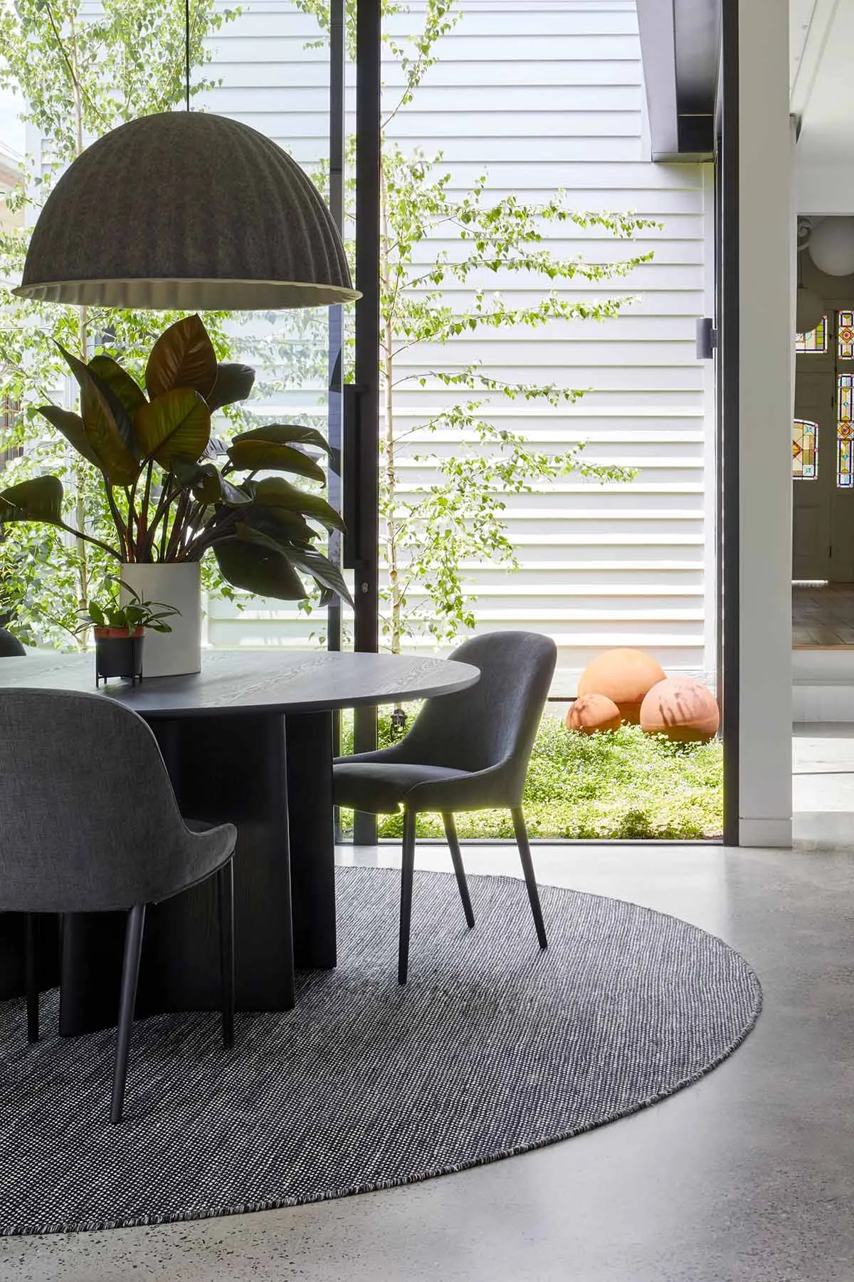 Modern living room with a wooden table, fabric chairs, and metal frame.