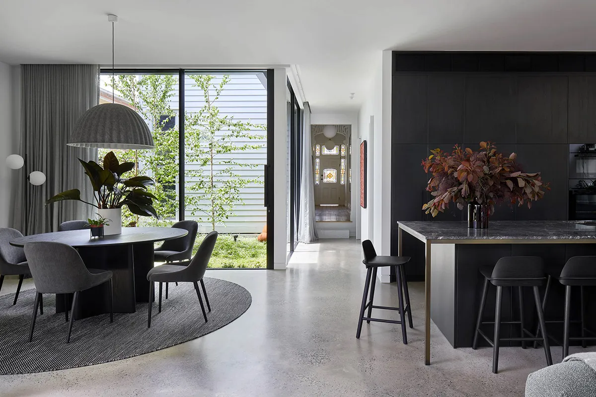 A modern living space featuring a concrete floor, dark wood furniture, and marble countertops.