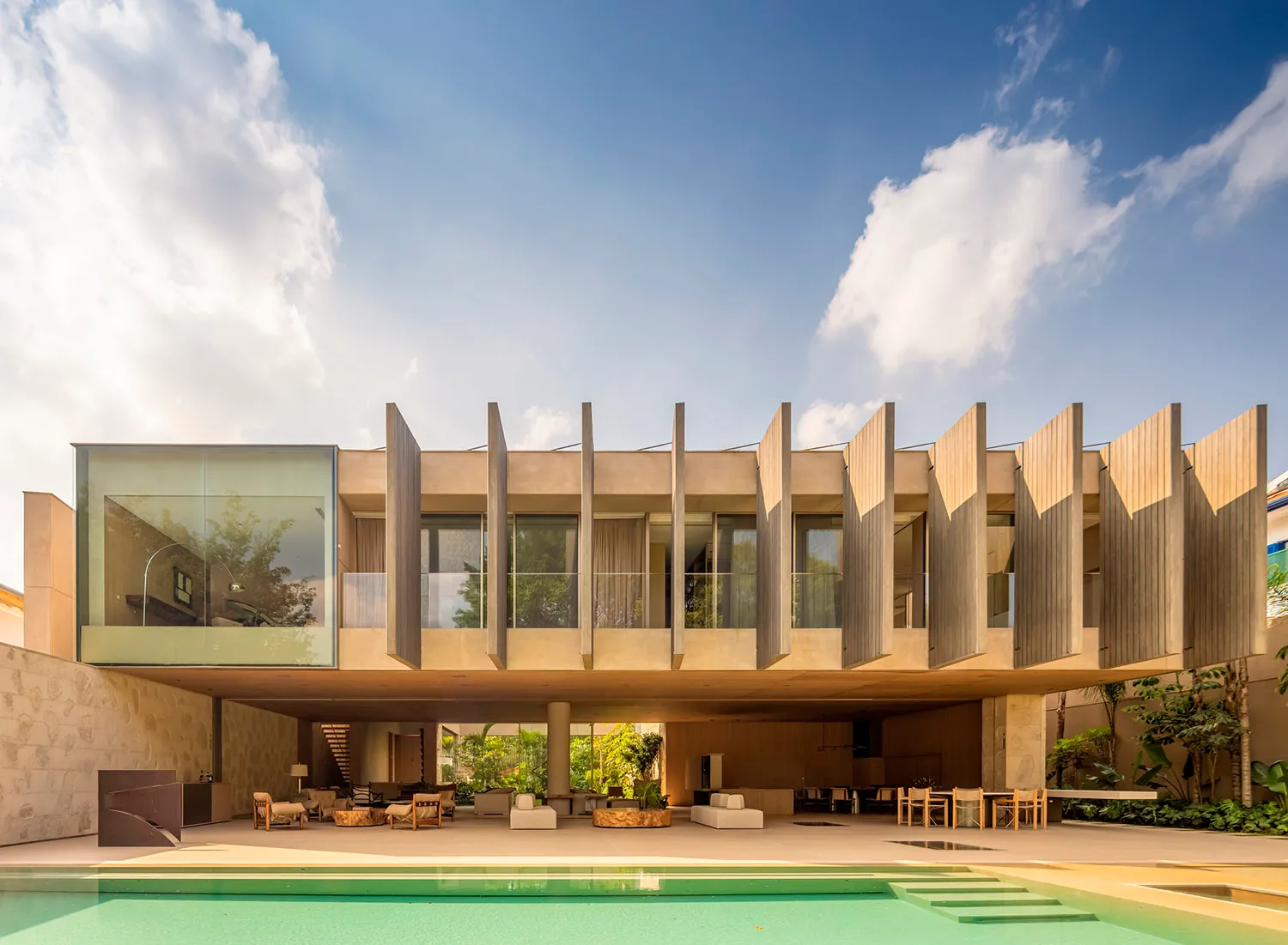 A modern residential interior featuring concrete, glass, and wood materials.