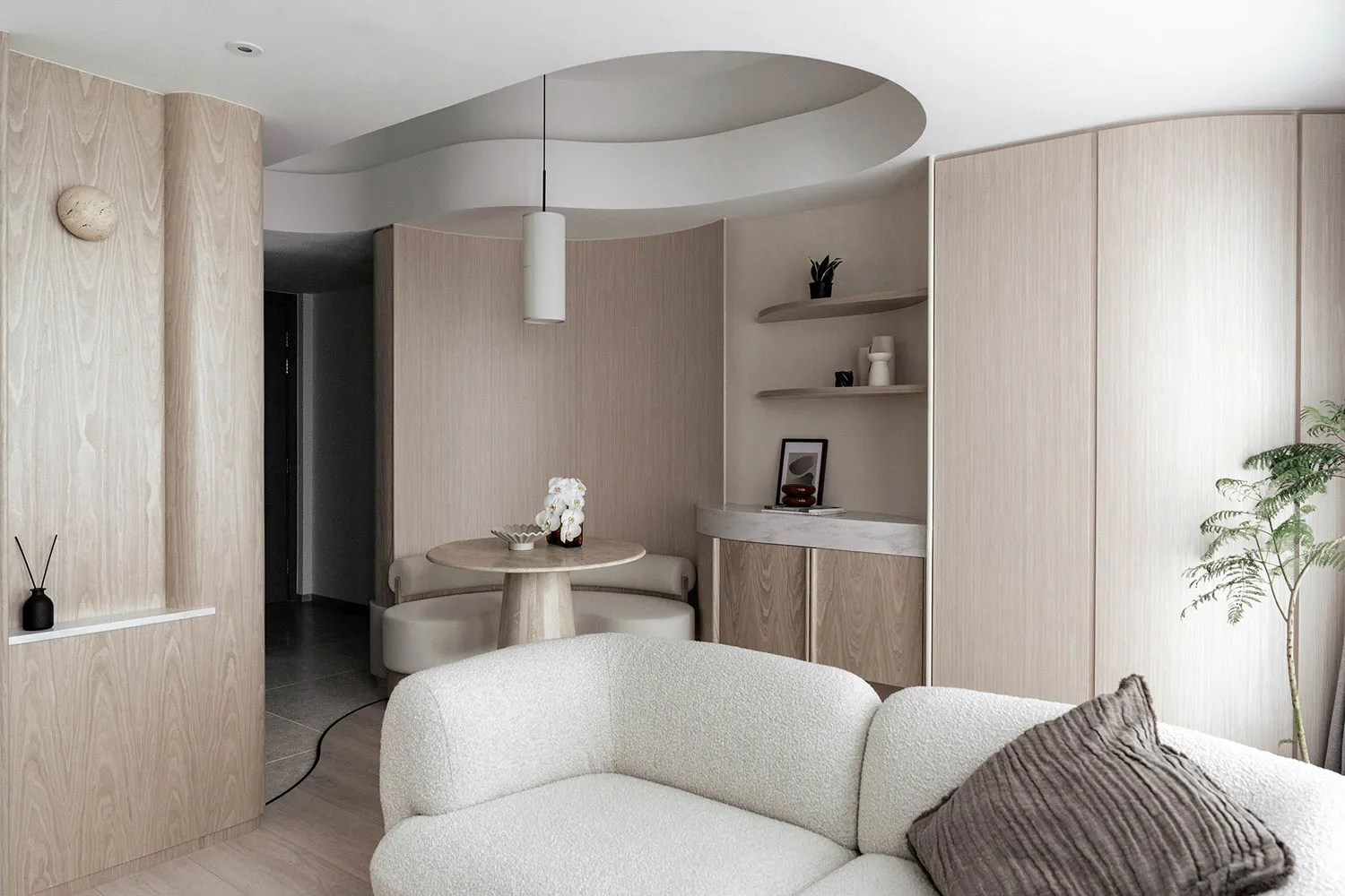 A modern residential interior featuring wooden cabinets and a white sofa with a brown pillow.