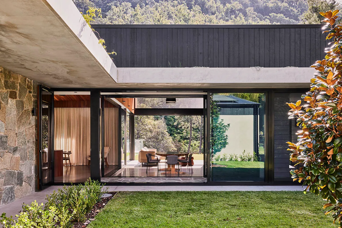 Modern residential house with stone, concrete, and glass exterior materials.