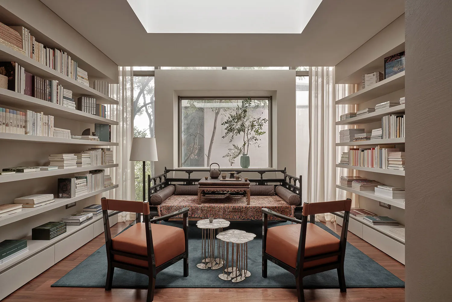 A modern living room with bookshelves, comfortable seating, and a cozy atmosphere.