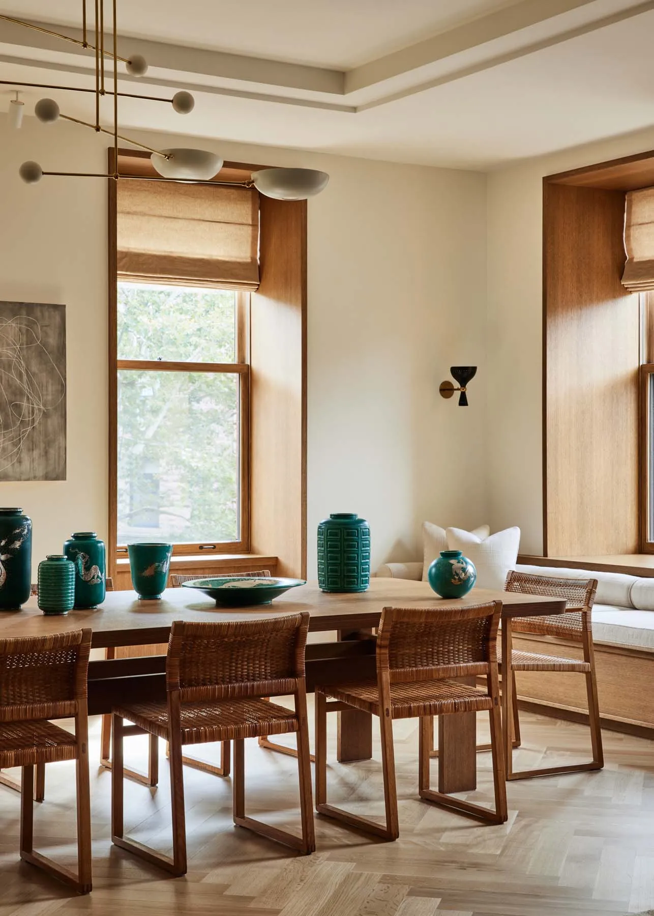 A minimalist interior design with wooden furniture, large windows, and green vases.